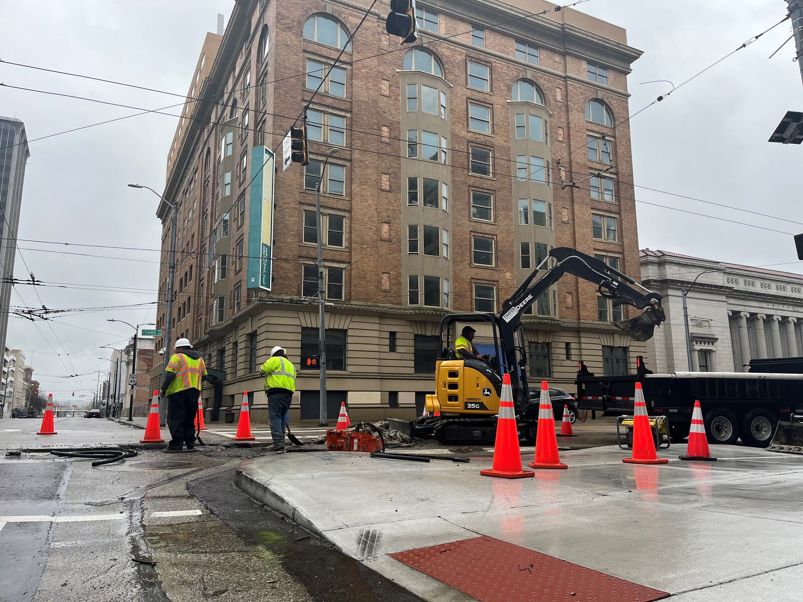 Construction crews work on the roadway across the street from the former Dayton Grand Hotel building at 11 S. Ludlow St. CORNELIUS FROLIK / STAFF