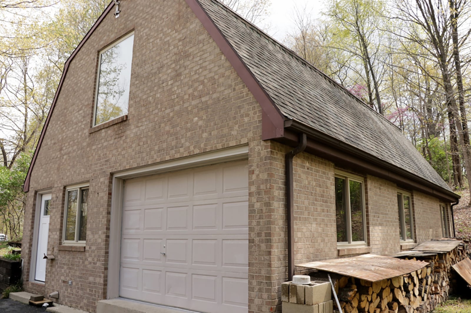 A matching brick out-building has a front entrance door, a single-car overhead door, both accessible from a parking pad. Inside, the building has a wood-burning stove, 2 electric heaters, a work bench, storage closets and a full bathroom. The upper level has a natural ramp to an overhead bay door that allows for storage of lawn equipment. CONTRIBUTED PHOTO BY KATHY TYLER