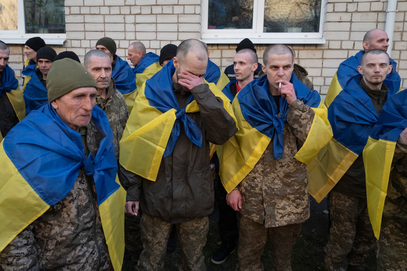 Ukrainian servicemen react after returning from captivity during a POWs exchange between Russia and Ukraine, in Ukraine, Wednesday, March 19, 2025. (AP Photo/Efrem Lukatsky)