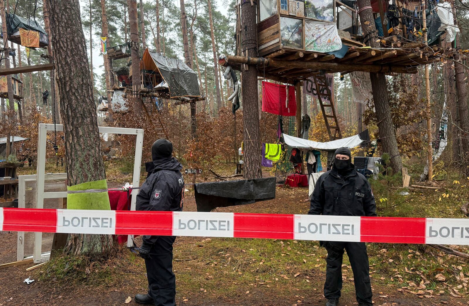 FILE - Police officers stand at the Tesla protest camp in the forest near the car factory in Grünheide, Germany, Tuesday Nov. 19, 2024. (Lutz Deckwerth/dpa via AP, File)