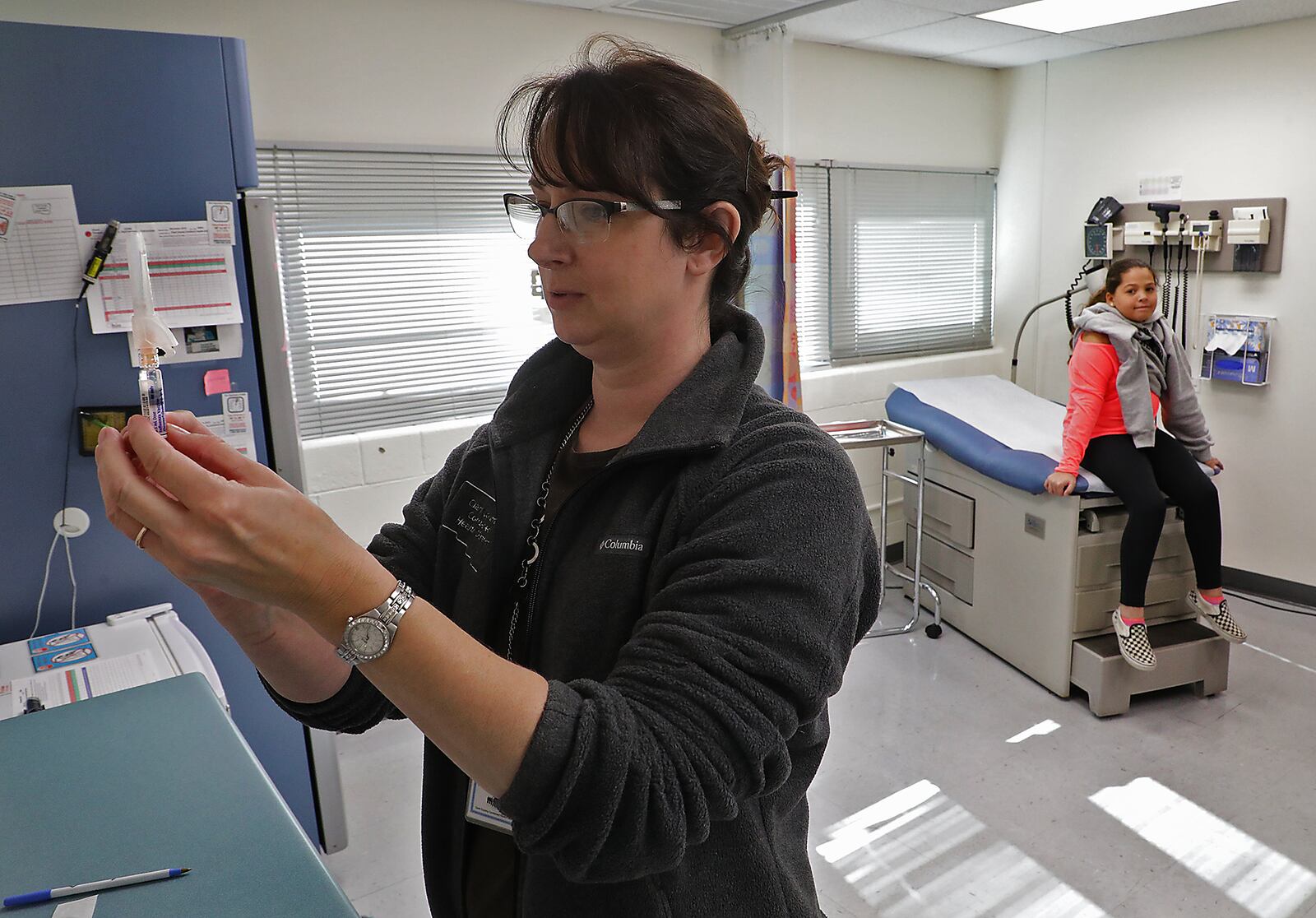 Kristen Earley, a nurse at the Clark County Combined Health District, gets a flu shot ready. BILL LACKEY/STAFF