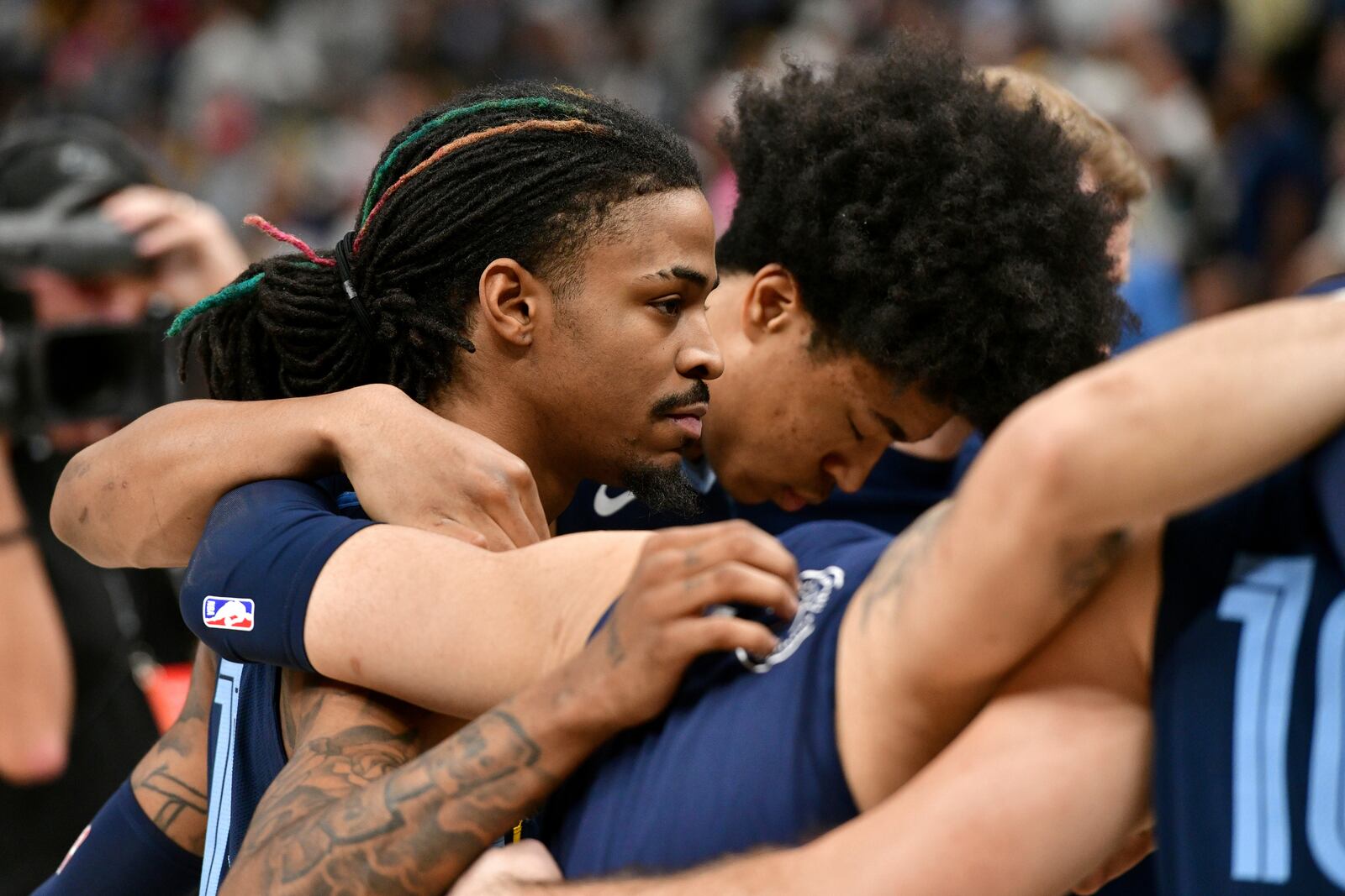 Memphis Grizzlies guard Ja Morant, left, forward Jaylen Wells huddle with their team after a man collapsed courtside just before the start of an NBA basketball game against the San Antonio Spurs, Monday, Feb. 3, 2025, in Memphis, Tenn. (AP Photo/Brandon Dill)