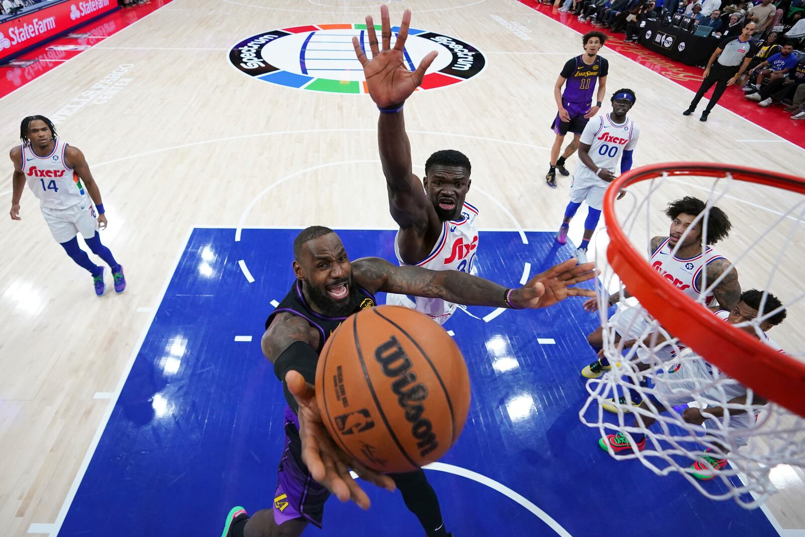 Los Angeles Lakers' LeBron James, bottom goes up for a shot against Philadelphia 76ers' Adem Bona during the second half of an NBA basketball game, Tuesday, Jan. 28, 2025, in Philadelphia. (AP Photo/Matt Slocum)