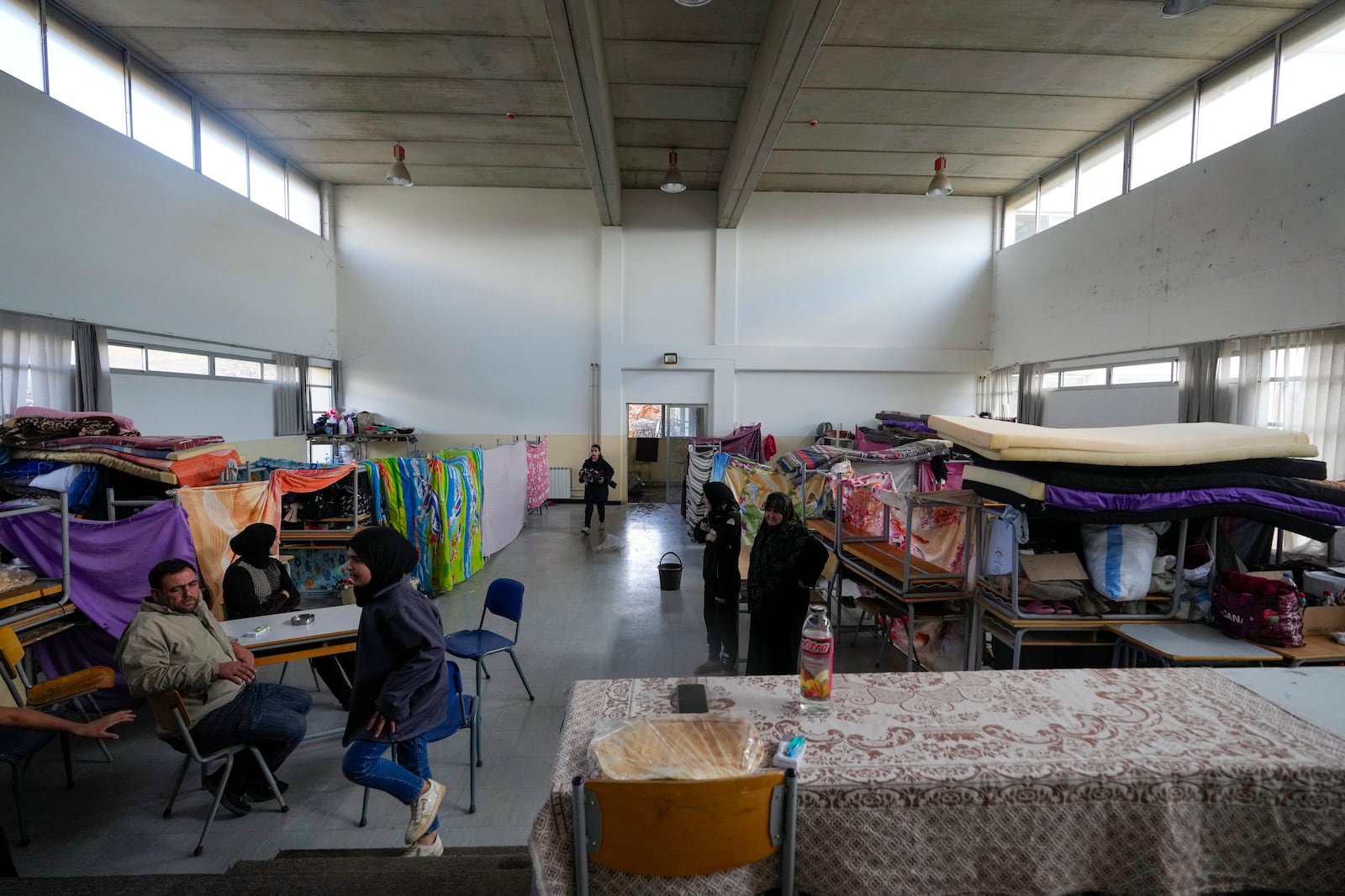 Displaced people, who fled Baalbek city and the nearby towns of Douris and Ain Bourday amid the ongoing Hezbollah-Israel war, sit at a school being used as a shelter, in Deir Al-Ahmar, east Lebanon, Thursday, Oct. 31, 2024. (AP Photo/Hassan Ammar)