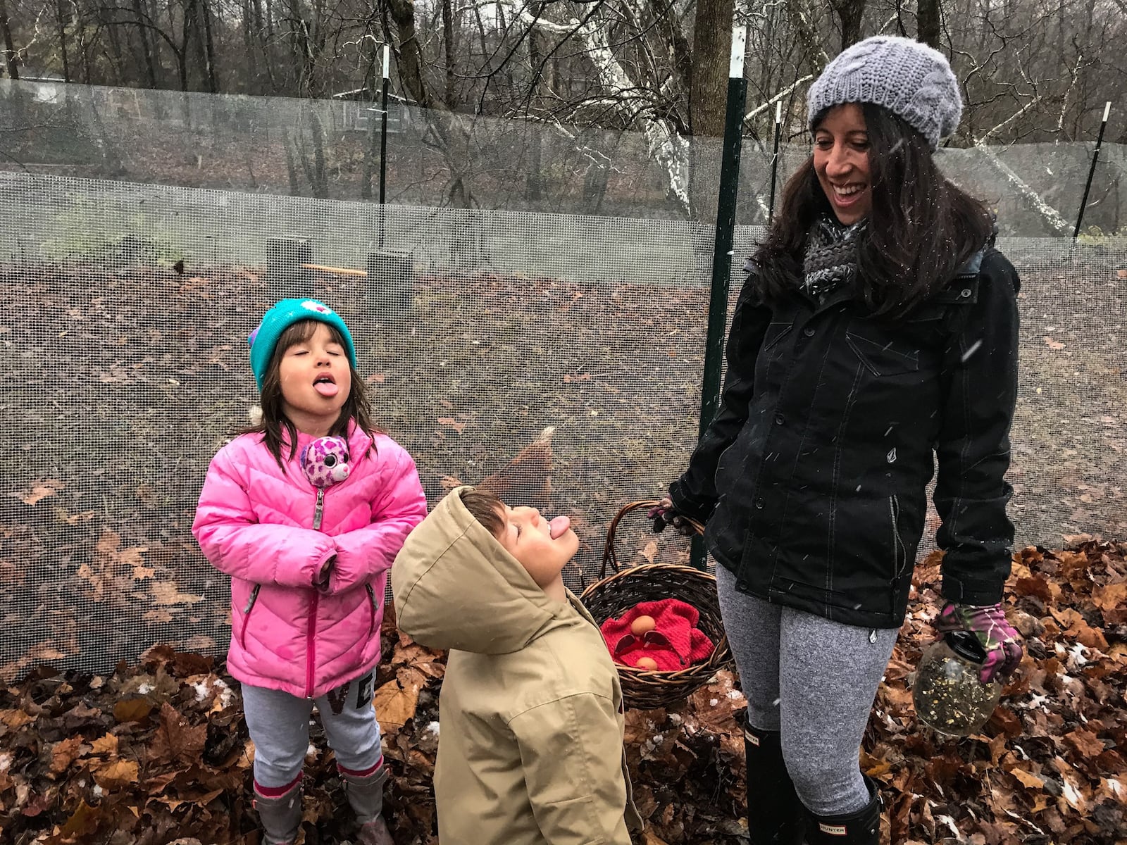 Aja Delaney and her two children, Maelina Spoores, left and Logan Rio Spoores collect eggs from the backyard chickens. Delaney works from home and is considering leaving her job if her kids' Montessori school has to close again due to the COVID-19.