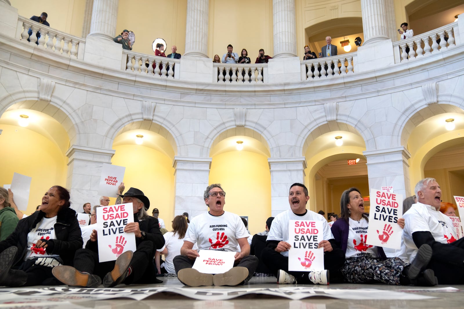 Demonstrators protest against cuts to American foreign aid spending, including USAID and the PEPFAR program to combat HIV/AIDS, at the Cannon House Office Building on Capitol Hill, Wednesday, Feb. 26, 2025, in Washington. (AP Photo/Mark Schiefelbein)