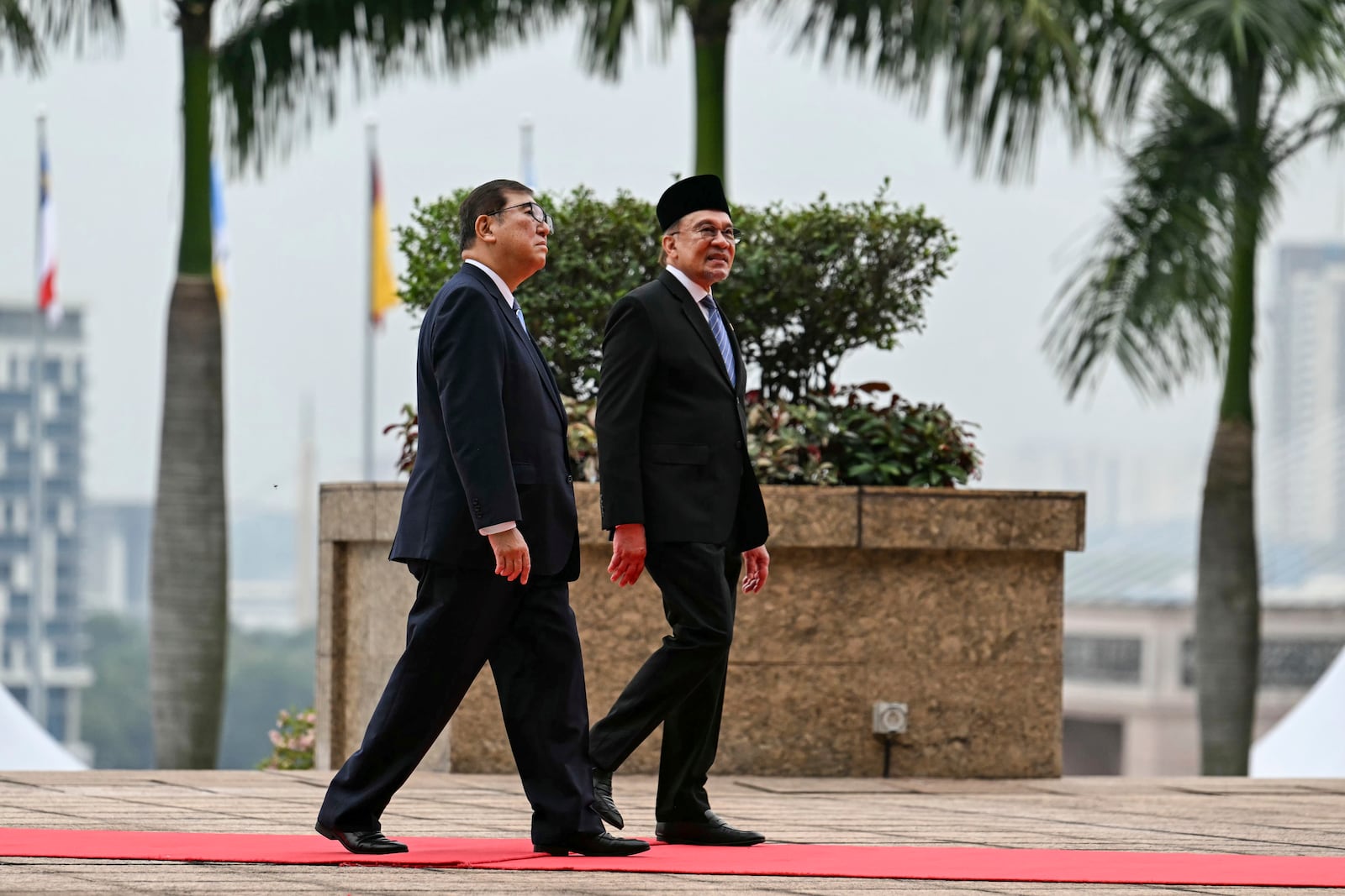 Malaysia's Prime Minister Anwar Ibrahim, right, and Japan's Prime Minister Shigeru Ishiba walk towards the prime minister's office after the welcoming ceremony in Putrajaya, Malaysia, Friday, Jan. 10, 2025. (Mohd Rasfan/Pool Photo via AP)