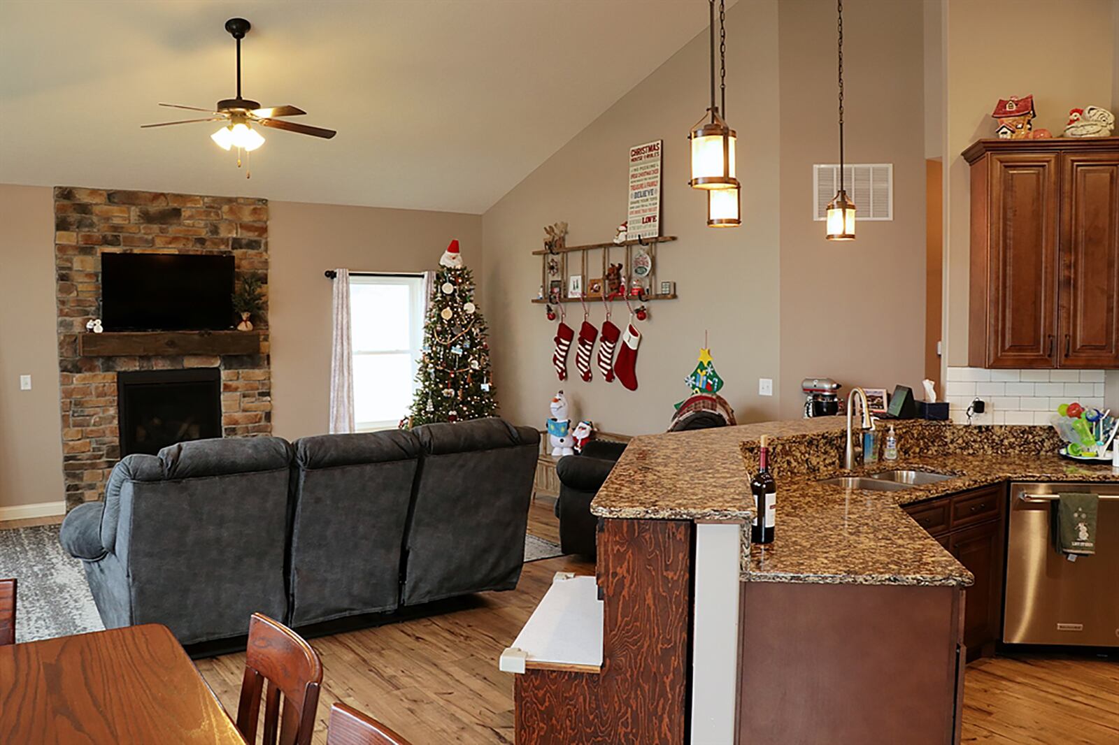 A cathedral ceiling peaks above the combined social areas of the great room, dining room and kitchen. The centerpiece to the great room is a stone, gas fireplace with wood beam mantel and stone hearth. CONTRIBUTED PHOTO BY KATHY TYLER