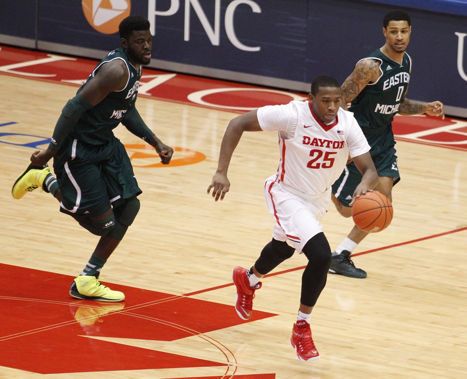 Dayton forward Kendall Pollard dribbes ahead of Eastern Michigan’s Olalekan Ajayi, left, and Raven Lee, right, on Saturday, Dec. 6, 2014, at UD Arena. David Jablonski/Staff