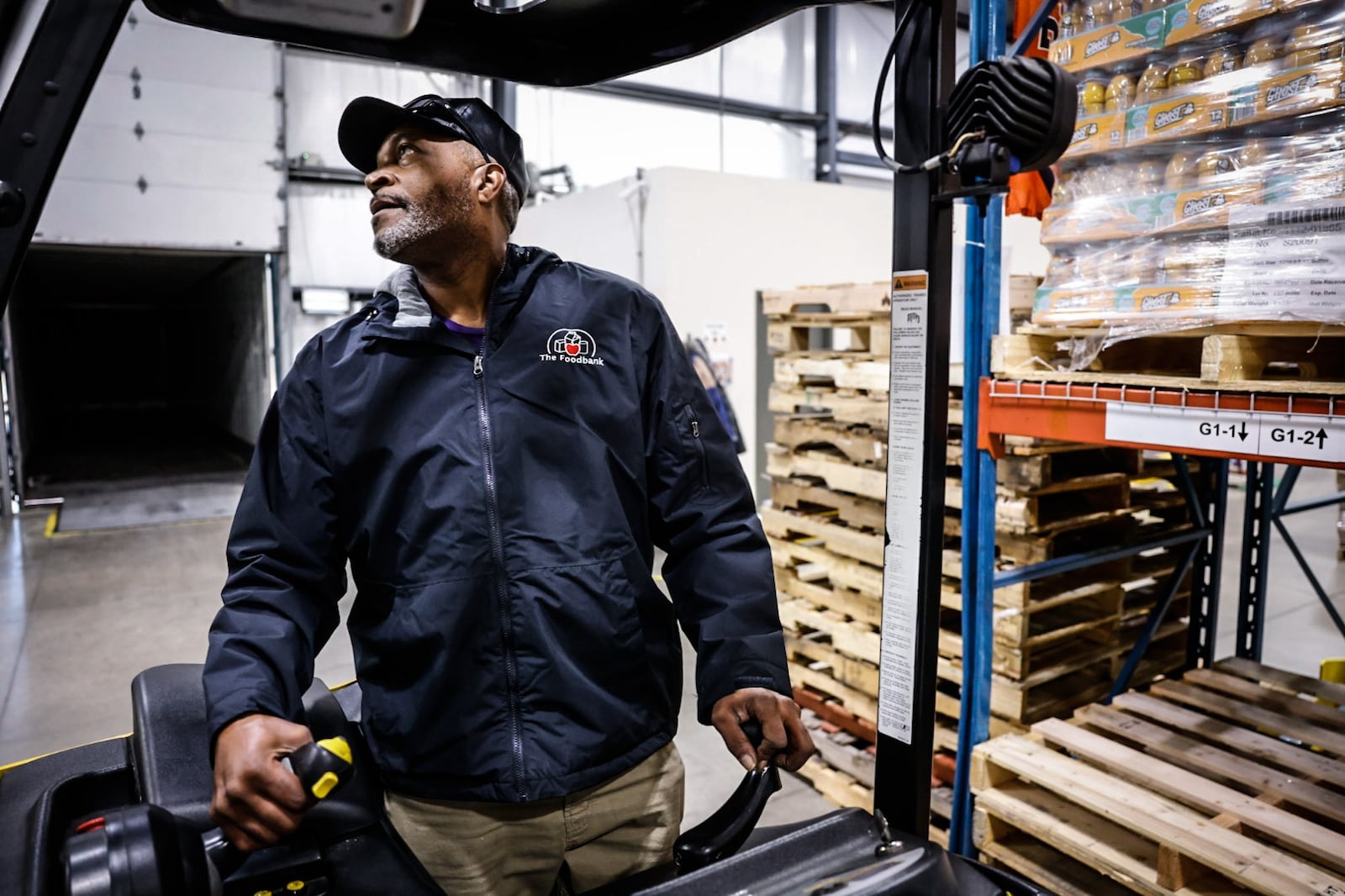 Foodbank Inc. employee El Logan moves crates of food around the warehouse on Armor Place in Dayton Thursday November 7, 2024. JIM NOELKER/STAFF