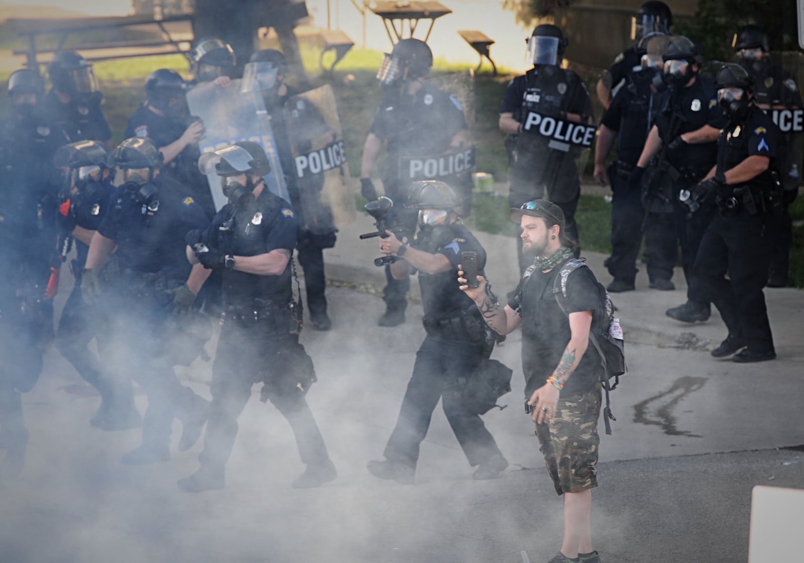 Dayton police deploy tear gas to disperse the crowd of protesters Saturday after some began to riot, damaging police cruisers and businesses in the city. MARSHALL GORBY / STAFF