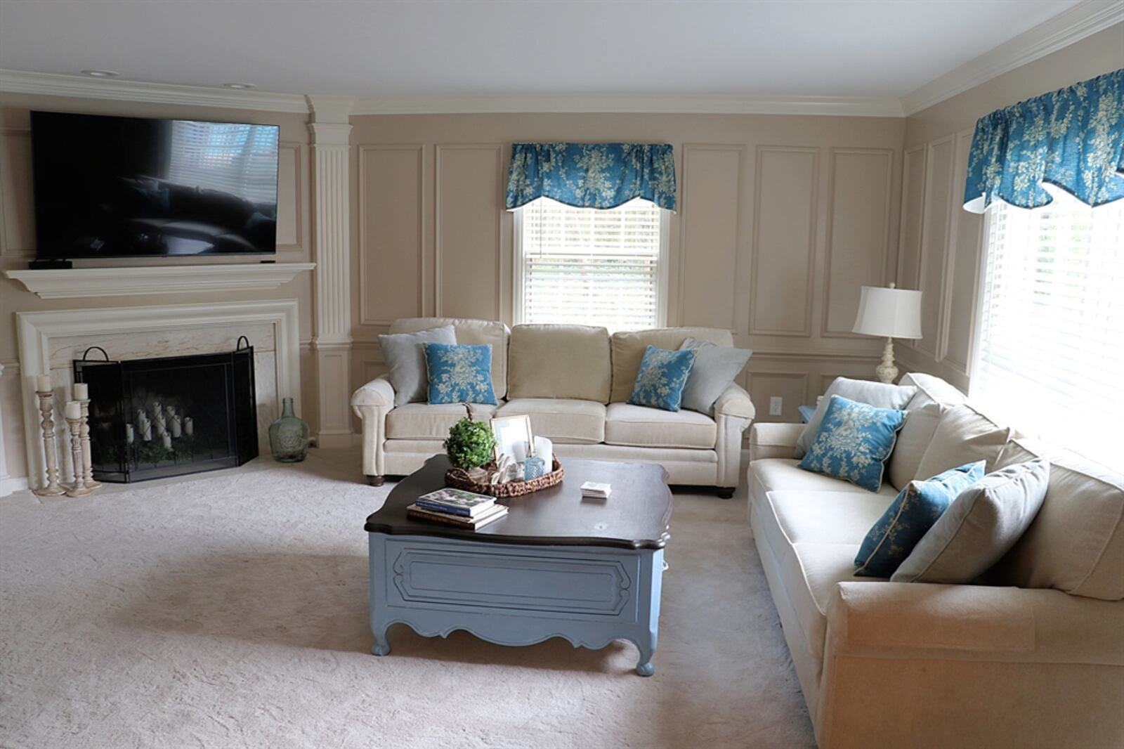 The family room features wainscoting and a corner fireplace with fluted wood mantel and white marble surround.