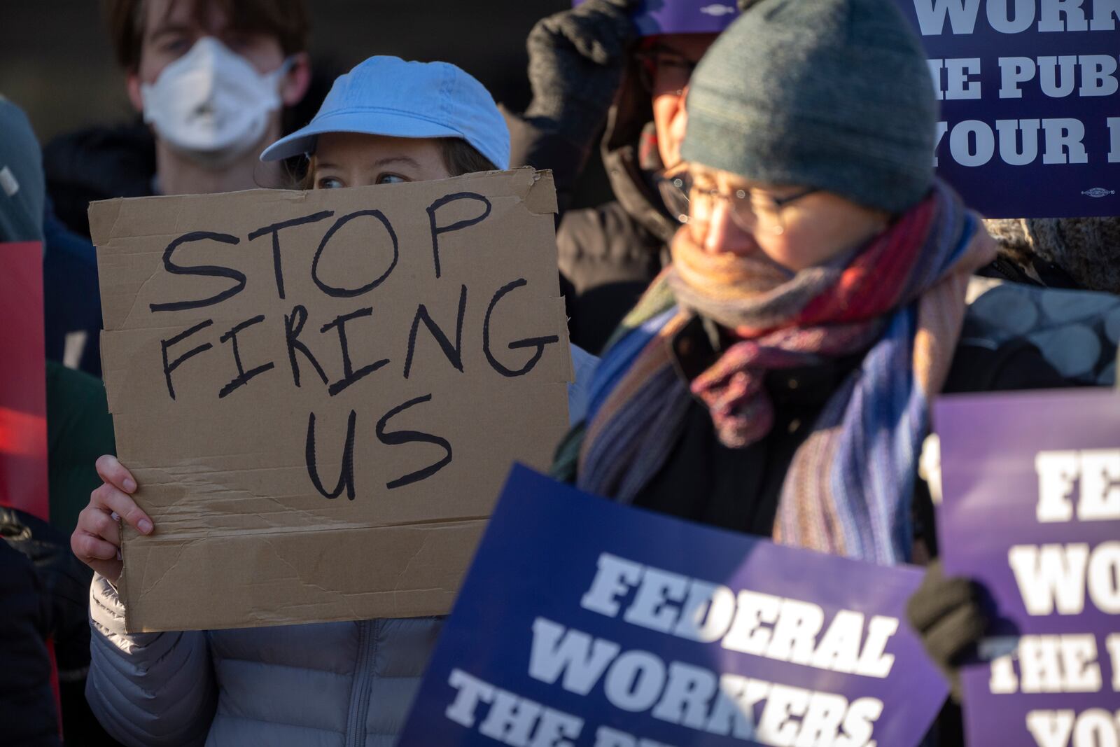 Demonstrators rally in support of federal workers outside of the Department of Health and Human Services, Friday, Feb. 14, 2025, in Washington. (AP Photo/Mark Schiefelbein)