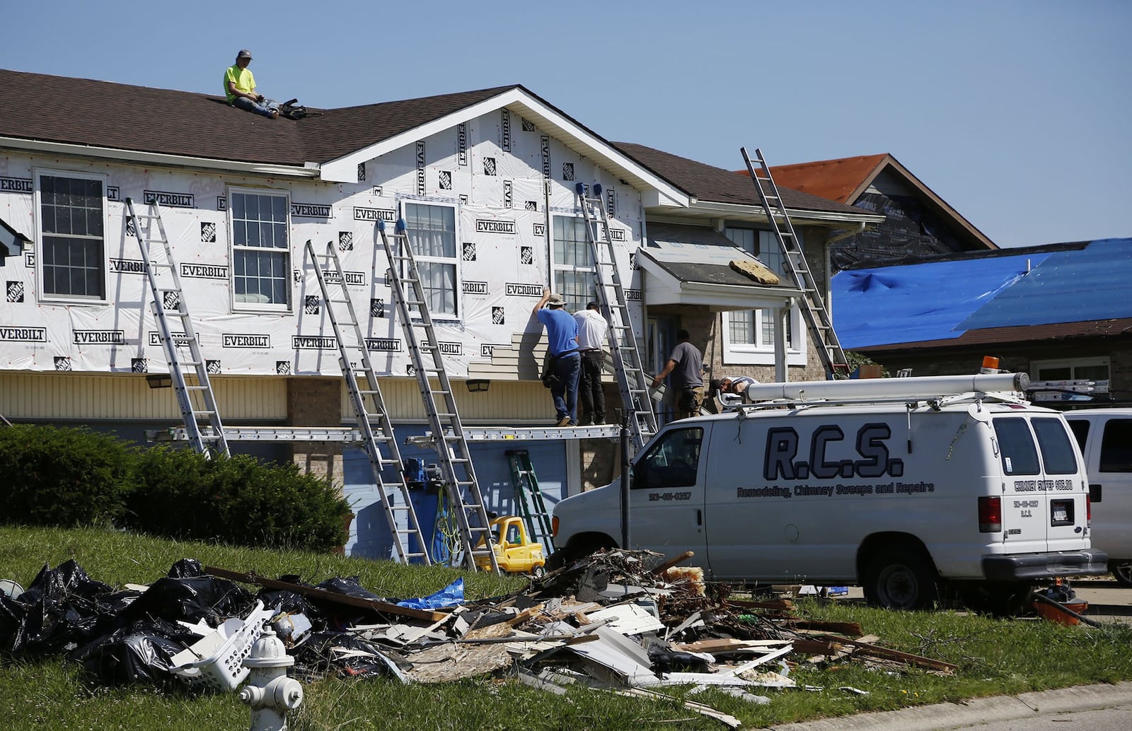 A small fraction of repairs to homes and apartments have been completed nearly a month after the Memorial Day tornadoes struck. This duplex on North Knoll Drive in Beavercreek is getting new siding and roof repair. TY GREENLEES / STAFF