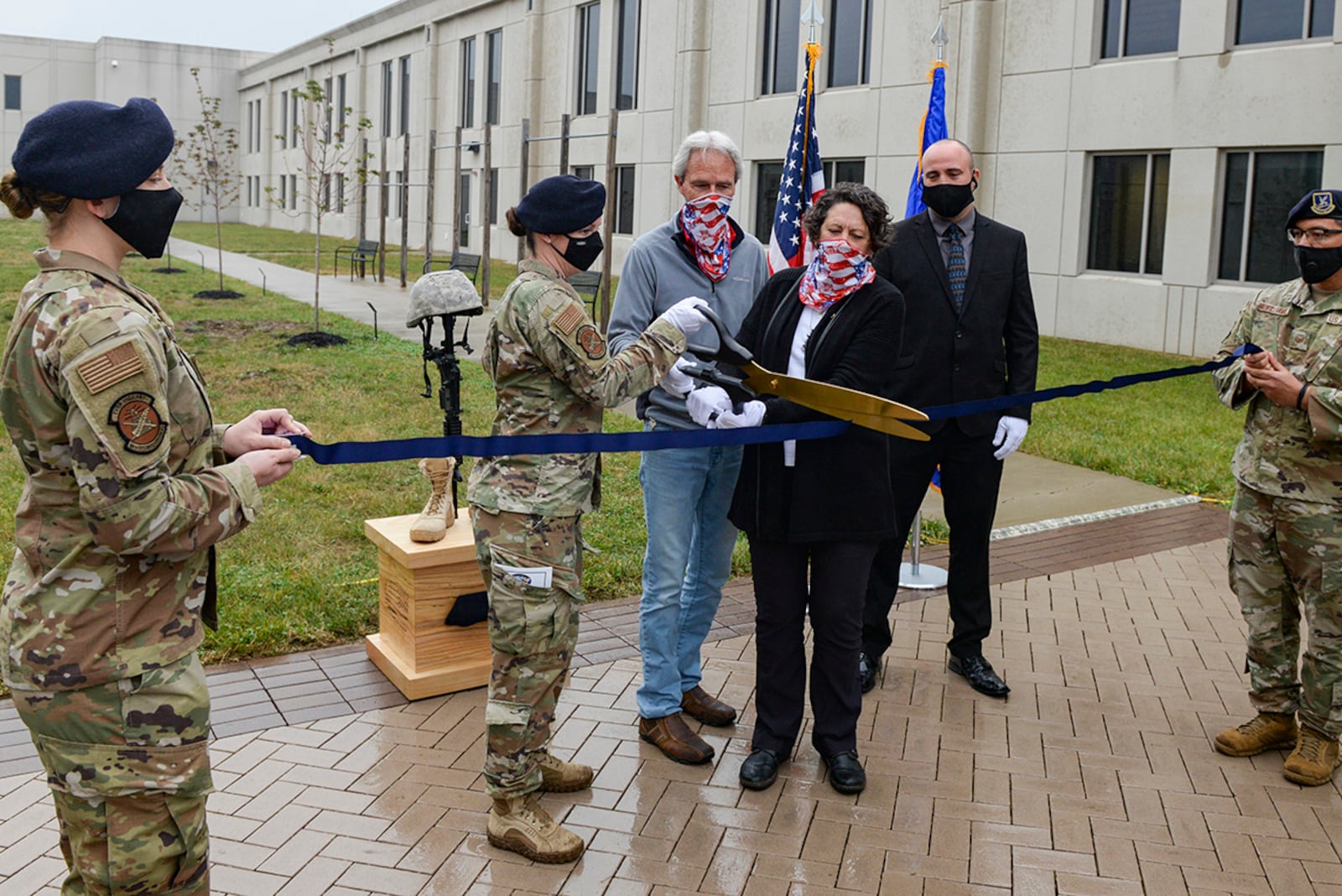 Maj. Julie Roloson, 88th Security Forces commander, and Gold Star family members, Chris Herwick and Don Herwick, cut the ribbon to officially open the Defenders Grove at Wright-Patterson Air Force Base Oct. 21. Defenders Grove is made up of 14 trees, each dedicated to the memory of a fallen 88th Security Forces Squadron Defender who paid the ultimate sacrifice during Operation Iraqi Freedom and Operation Enduring Freedom. U.S. AIR FORCE PHOTO/WESLEY FARNSWORTH