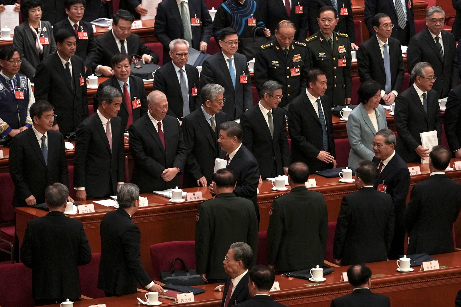 Chinese President Xi Jinping, center, is followed by his Premier Li Qiang as they leave the hall after attending the opening session of the National People's Congress at the Great Hall of the People in Beijing, Wednesday, March 5, 2025. (AP Photo/Andy Wong)