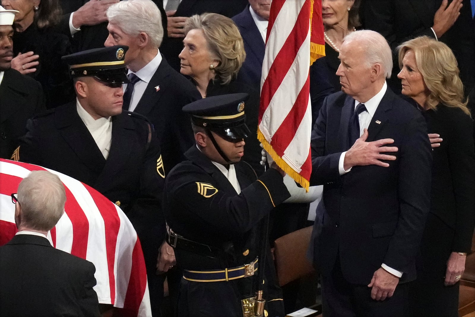 President Joe Biden and first lady Jill Biden watch as a joint services body bearer team carries the casket of former President Jimmy Carter during the state funeral at Washington National Cathedral in Washington, Thursday, Jan. 9, 2025. (AP Photo/Jacquelyn Martin)