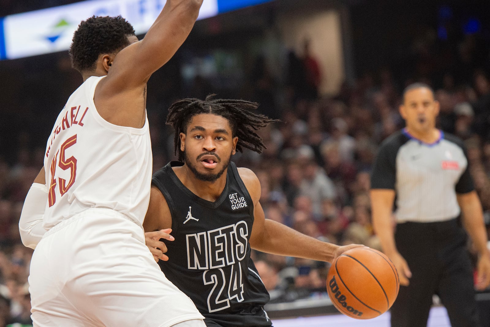 Brooklyn Nets' Cam Thomas (24) drives against Cleveland Cavaliers' Donovan Mitchell, left, during the first half of an NBA basketball game in Cleveland, Saturday, Nov. 9, 2024. (AP Photo/Phil Long)