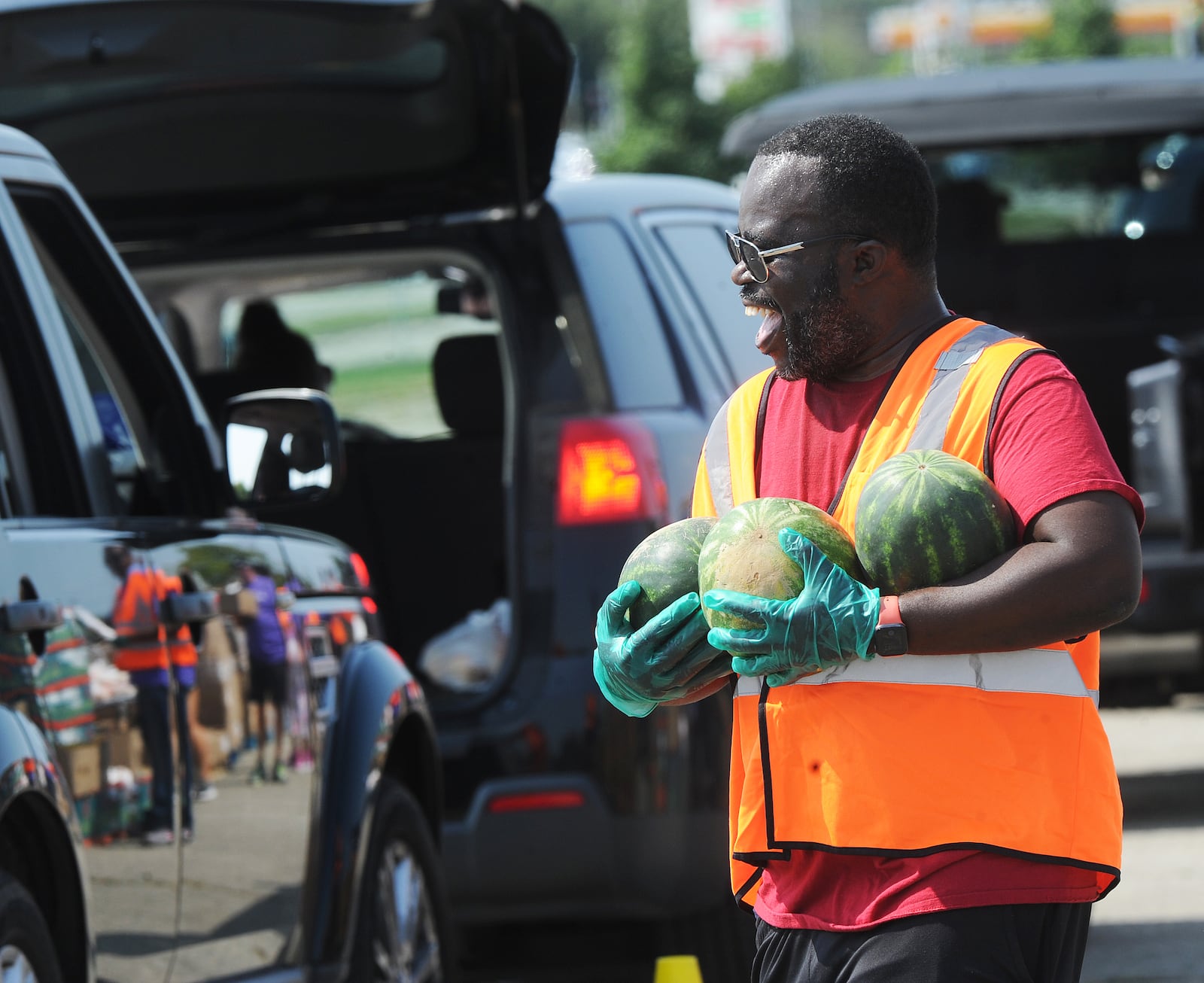 Veto Mason helps with The Foodbank Inc. drive-thru food distribution at the old Salem Mall in Trotwood Thursday Sept. 15, 2022. MARSHALL GORBY\STAFF