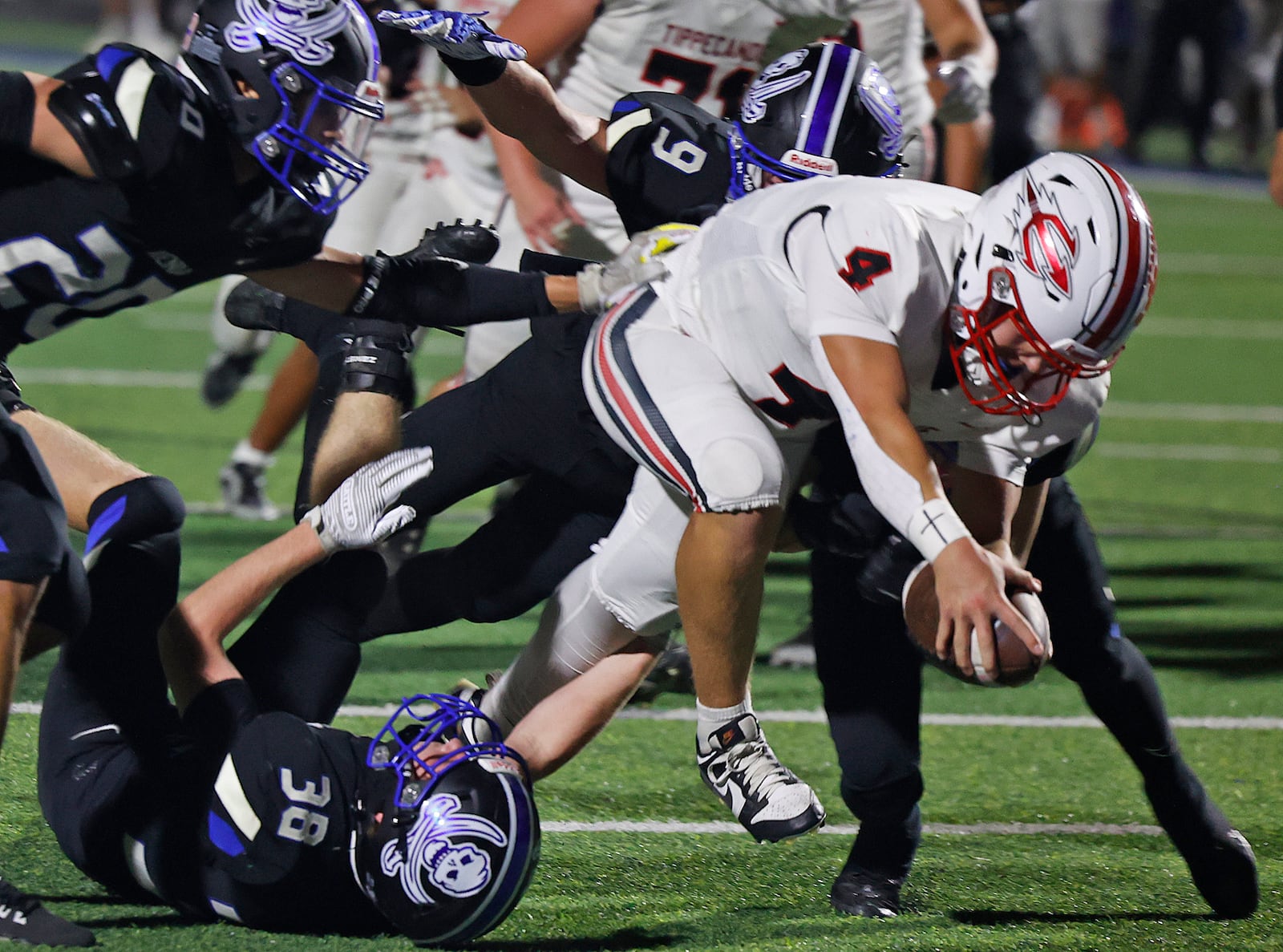 Tipp's Larkin Thomas stretches into the end zone for a touchdown despite several Xenia defenders trying to tackle him. BILL LACKEY/STAFF