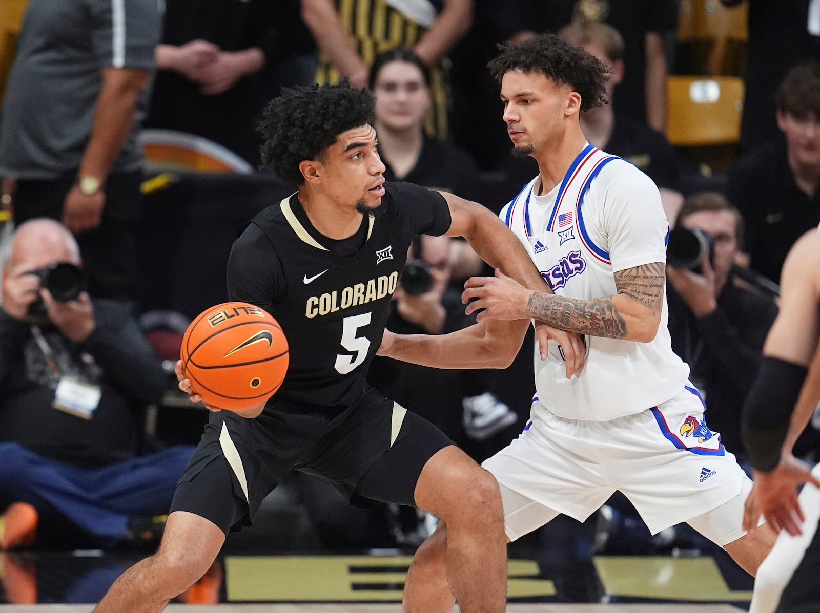 Colorado guard RJ Smith, left, looks to pass the ball as Kansas guard Zeke Mayo, right, defends in the first half of an NCAA college basketball game Monday, Feb. 24, 2025, in Boulder, Colo. (AP Photo/David Zalubowski)