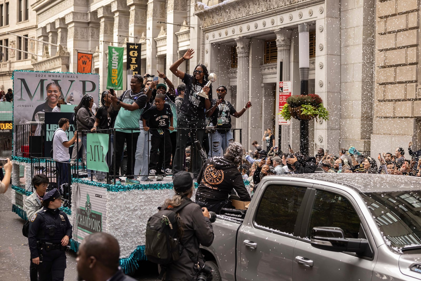 Members of the New York Liberty, including Jonquel Jones holding the MVP trophy, makes their way up Broadway during the WNBA basketball championship parade Thursday, Oct. 24, 2024, in New York. (AP Photo/Yuki Iwamura)