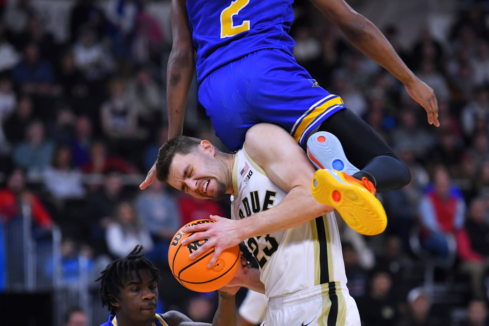 Purdue forward Camden Heide (23) hangs onto the ball while colliding with McNeese State guard DJ Richards Jr. (2) during the first half in the second round of the NCAA college basketball tournament, Saturday, March 22, 2025, in Providence, R.I. (AP Photo/Steven Senne)