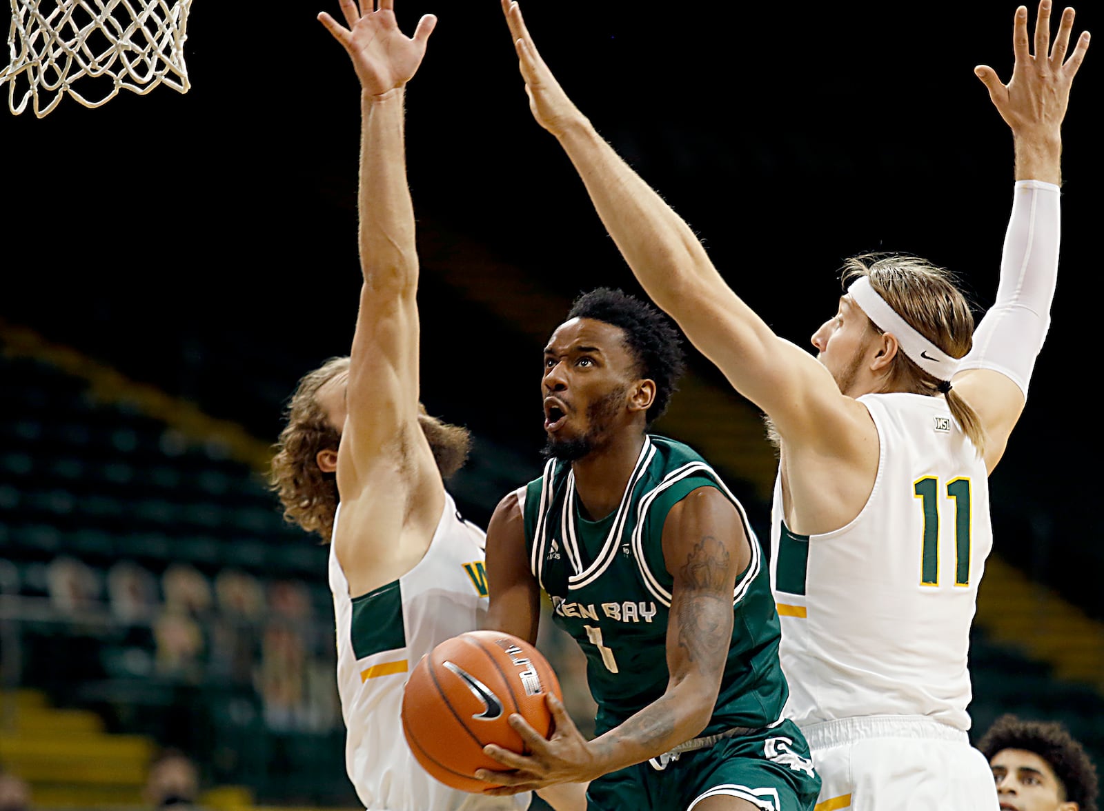 Green Bay guard Amari Davis goes up to score between Wright State’s Tim Finke and Loudon Love during a men's basketball game at the Nutter Center in Fairborn Saturday, Dec. 26, 2020. E.L. Hubbard/CONTRIBUTED