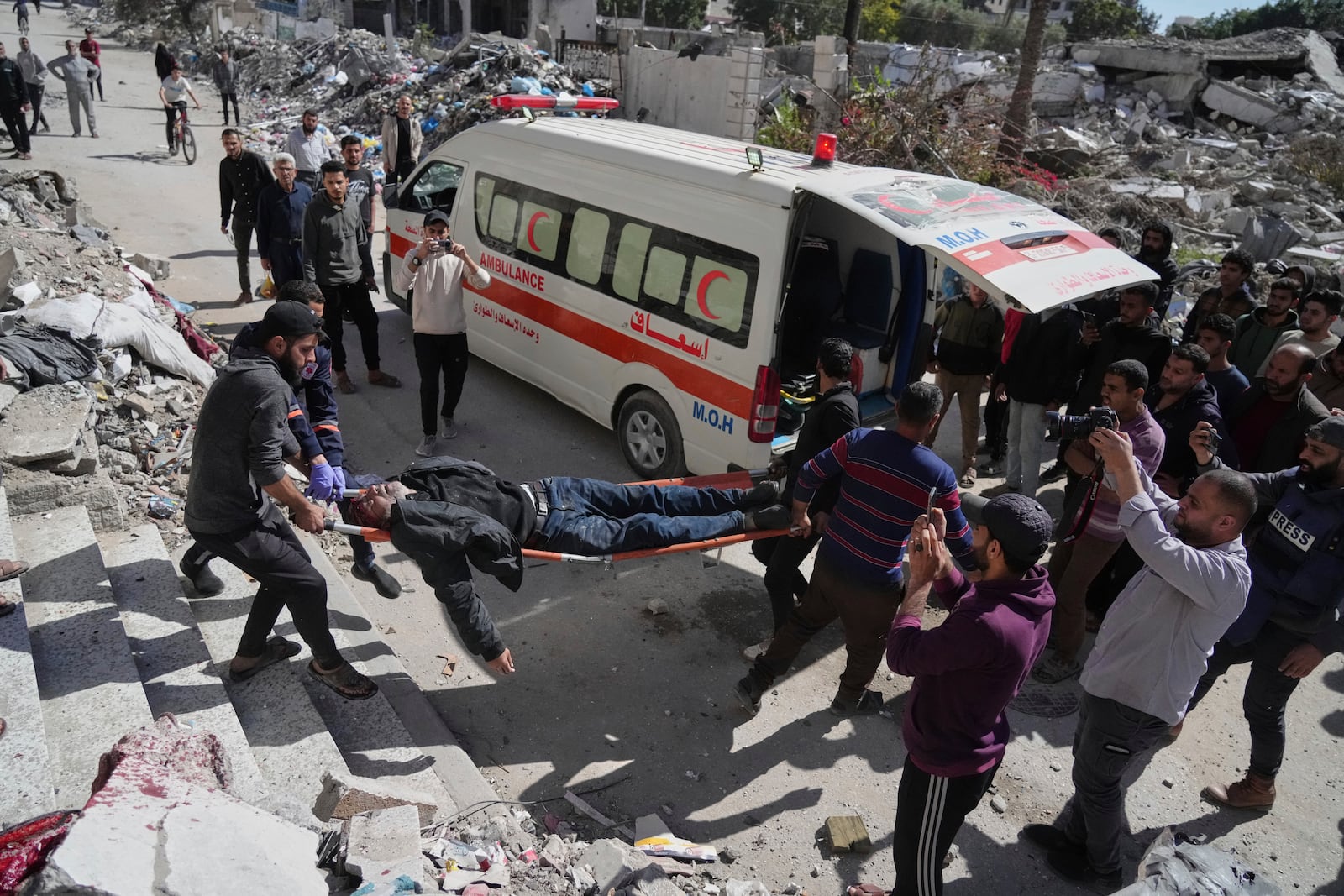 Palestinians evacuate an injured man after his house was hit by an Israeli bombardment in Gaza City, Wednesday, March 19, 2025. (AP Photo/Jehad Alshrafi)