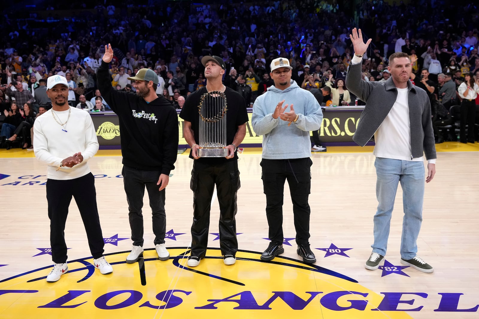 Members of the World Champion Los Angeles Dodgers, from left, Mookie Betts, Chris Taylor, Jack Flaherty, Brusdar Graterol and Freddie Freeman acknowledge fans during the first half of an NBA basketball game between the Los Angeles Lakers and Philadelphia 76ers, Friday, Nov. 8, 2024, in Los Angeles. (AP Photo/Mark J. Terrill)