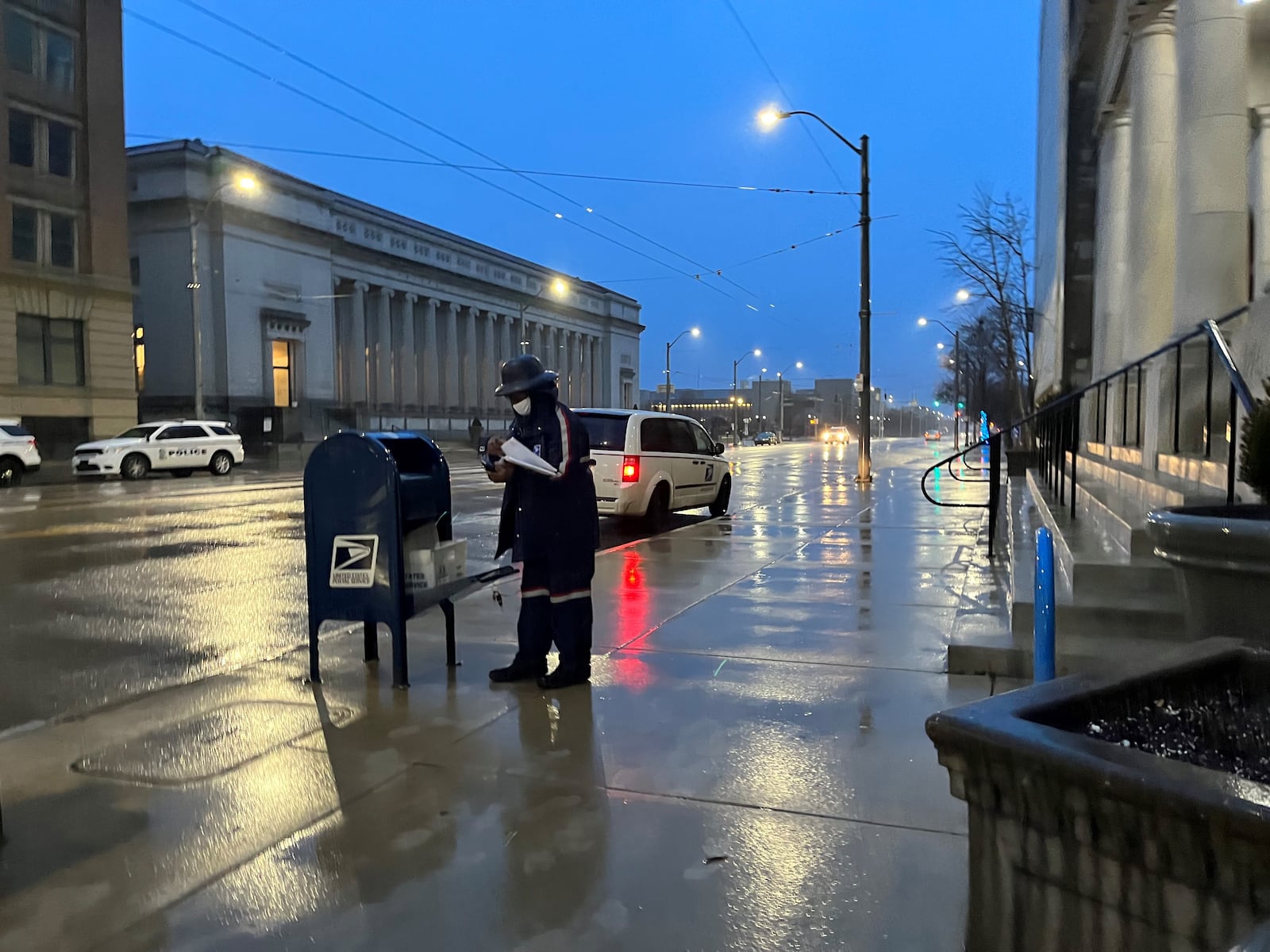 A U.S. Postal Service employee picks up mail outside of City Hall in downtown Dayton. CORNELIUS FROLIK / STAFF