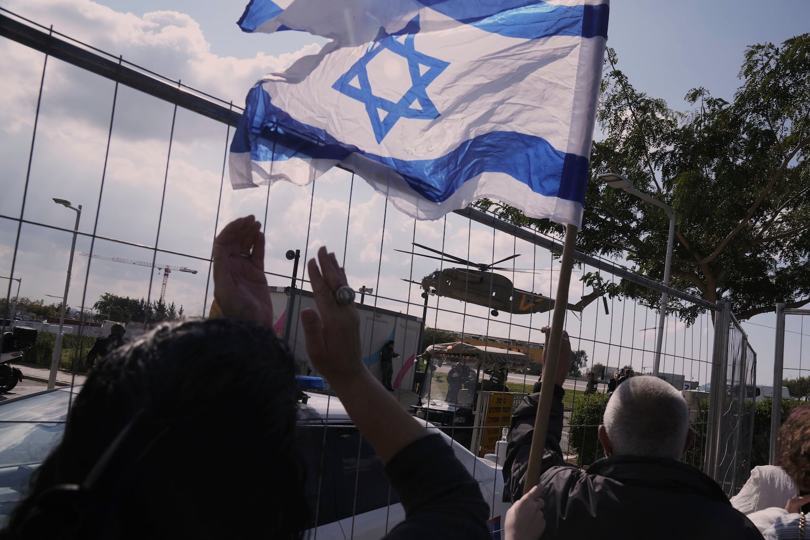 People react as an helicopter carrying Israeli Yarden Bibas, who has been released as part of a ceasefire in the Gaza Strip, lands at Sheba medical Center in Ramat Gan, Saturday Feb. 1, 2025. (AP Photo/Maya Alleruzzo)