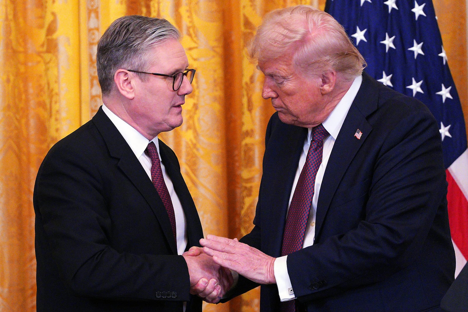 Britain's Prime Minister Keir Starmer, left, and U.S. President Donald Trump shake hands at a joint press conference in the East Room at the White House Thursday, Feb. 27, 2025, in Washington. (Carl Court/Pool Photo via AP)