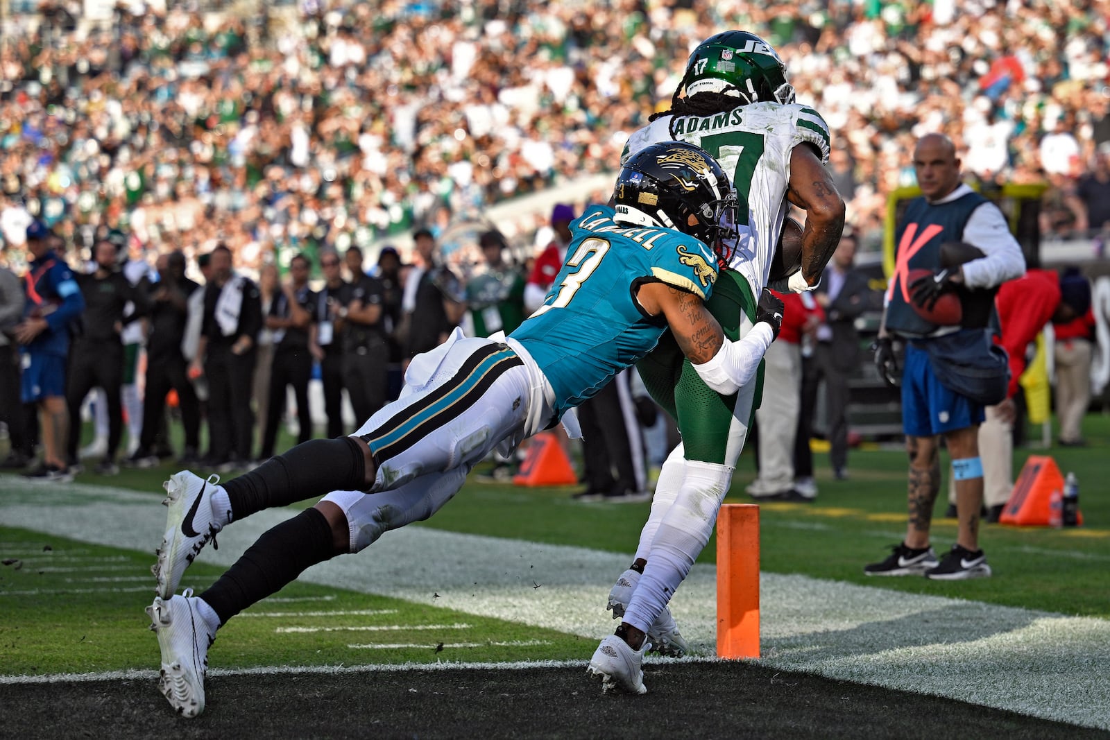 New York Jets wide receiver Davante Adams (17) is hit by Jacksonville Jaguars cornerback Tyson Campbell (3) after a sucessful two-point conversion during the second half of an NFL football game Sunday, Dec. 15, 2024, in Jacksonville, Fla. (AP Photo/Phelan M. Ebenhack)