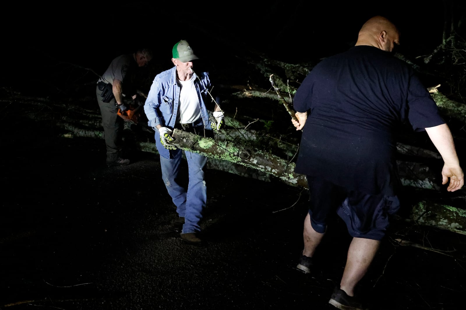 Locals help clear the roads from debris after a tornado passed through leaving a path of destruction, Saturday, March 15, 2025, in Plantersville, Ala. (AP Photo/Butch Dill)