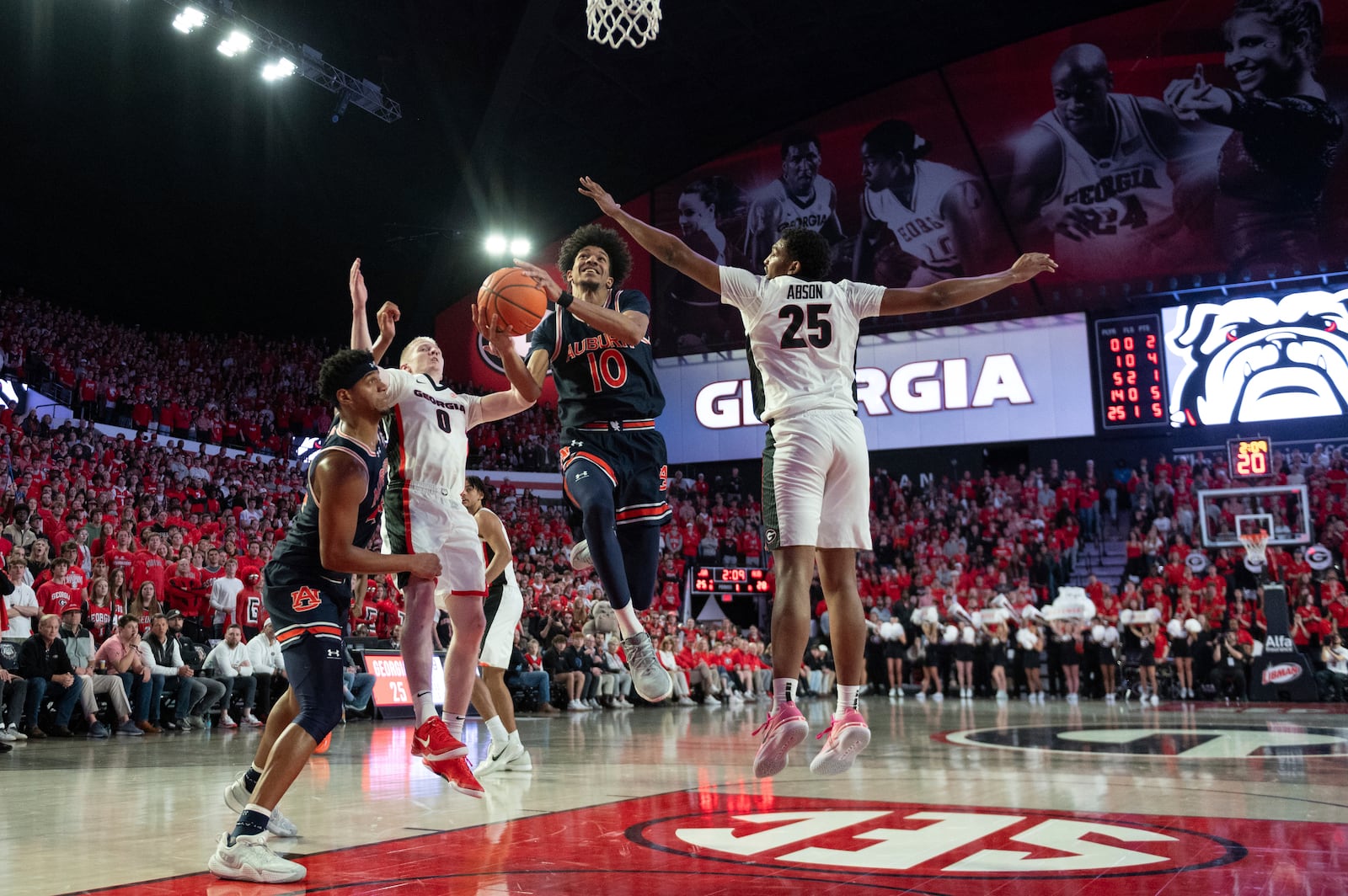 Auburn guard Chad Baker-Mazara (10) shoots betweem Georgia forward Justin Abson (25) and Georgia guard Blue Cain (0) during the first half of an NCAA college basketball game, Saturday, Jan. 18, 2025, in Athens, Ga. (AP Photo/Kathryn Skeean)