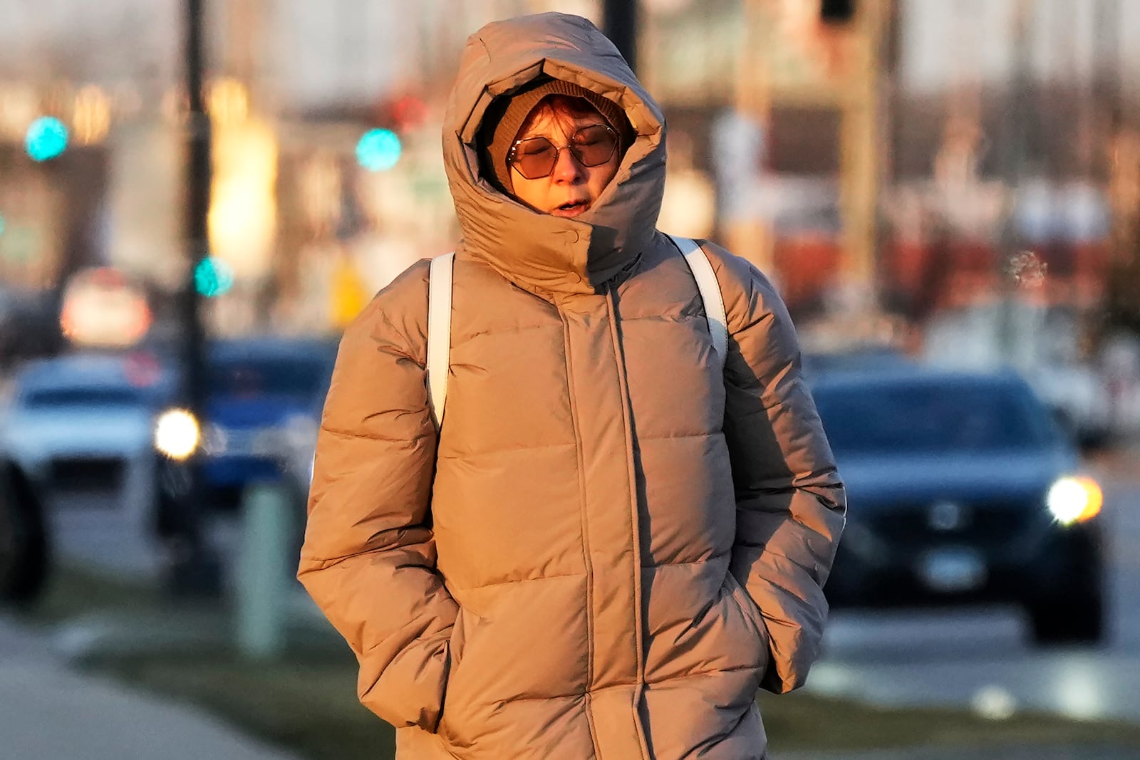 Pedestrian bundles up as she walks on the sidewalk during cold weather in Wheeling, Ill., Thursday, Dec. 12, 2024. (AP Photo/Nam Y. Huh)