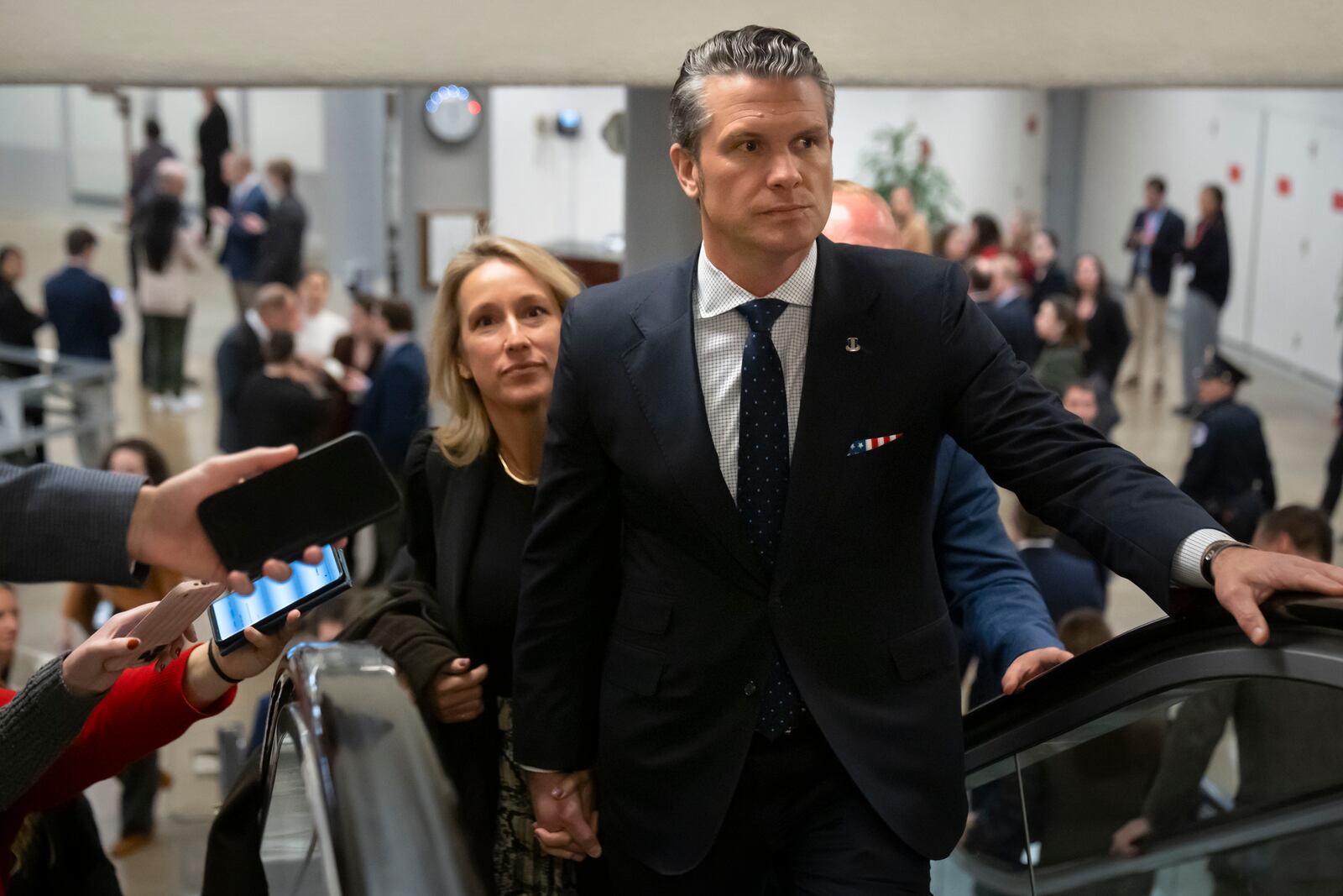 Pete Hegseth, President-elect Donald Trump's nominee to be defense secretary, is joined by his wife Jennifer Rauchet, as they walk through the basement of the Capitol, Wednesday, Dec. 4, 2024, in Washington. (AP Photo/Mark Schiefelbein)