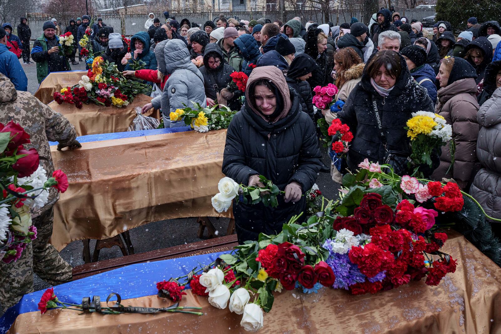 People come to say goodbye to Kateryna Zapishnya, 38, Diana Zapishnya, 12, Danyil Zapishnyi, 8, Serhii Zapishnyi, 40, Dmytro Yavorskyi, 37, Sofia Yavorska, 9, and Olena Yavorska 38, who were killed on Feb. 1 by a Russian strike on residential building during a funeral ceremony in Poltava, Ukraine, Wednesday, Feb. 5, 2025. (AP Photo/Evgeniy Maloletka)