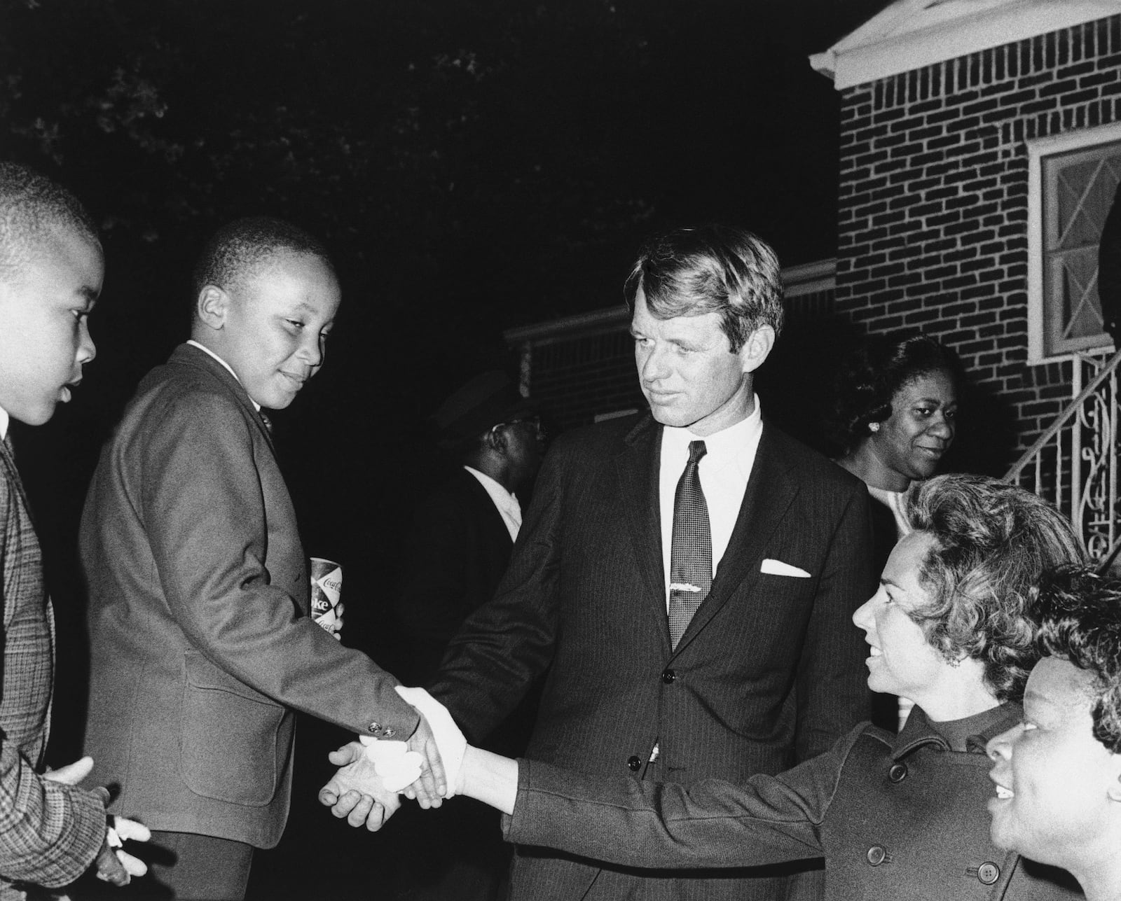 FILE - Ethel Kennedy shakes hands with Martin Luther King III after she and her husband Robert F. Kennedy, center, visited his mother Coretta Scott King, at her Atlanta home, April 8, 1968. Another of the slain civil rights leader Martin Luther King Jr's sons, Dexter, is at left. (AP Photo, File)