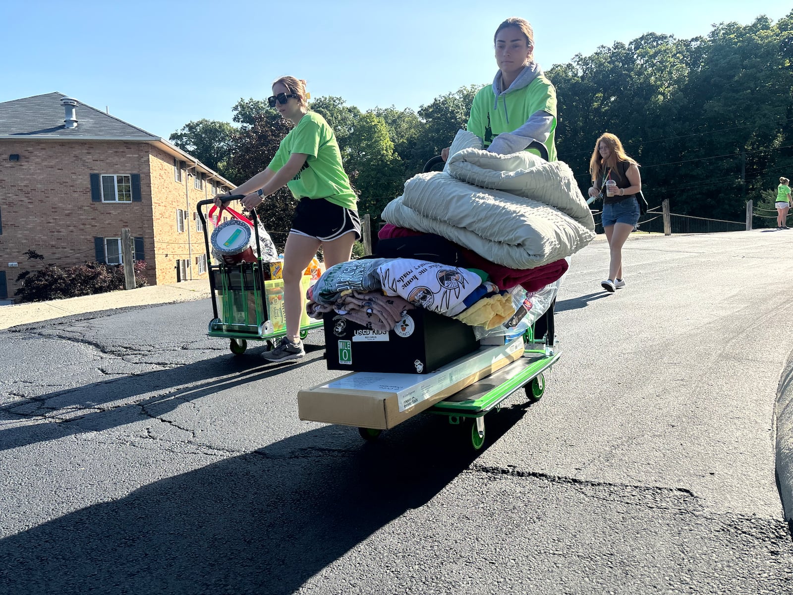 Volunteers in green shirts helped Kelley Philhower, back, move into her residence hall Wednesday morning at Wright State University. Eileen McClory/ Staff