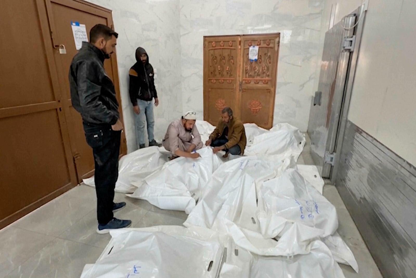 Palestinians gather in a morgue with the bodies of their relatives killed in Israeli airstrikes in the city of Khan Younis, southern Gaza Strip, Friday, Oct. 25, 2024. (AP Photo)