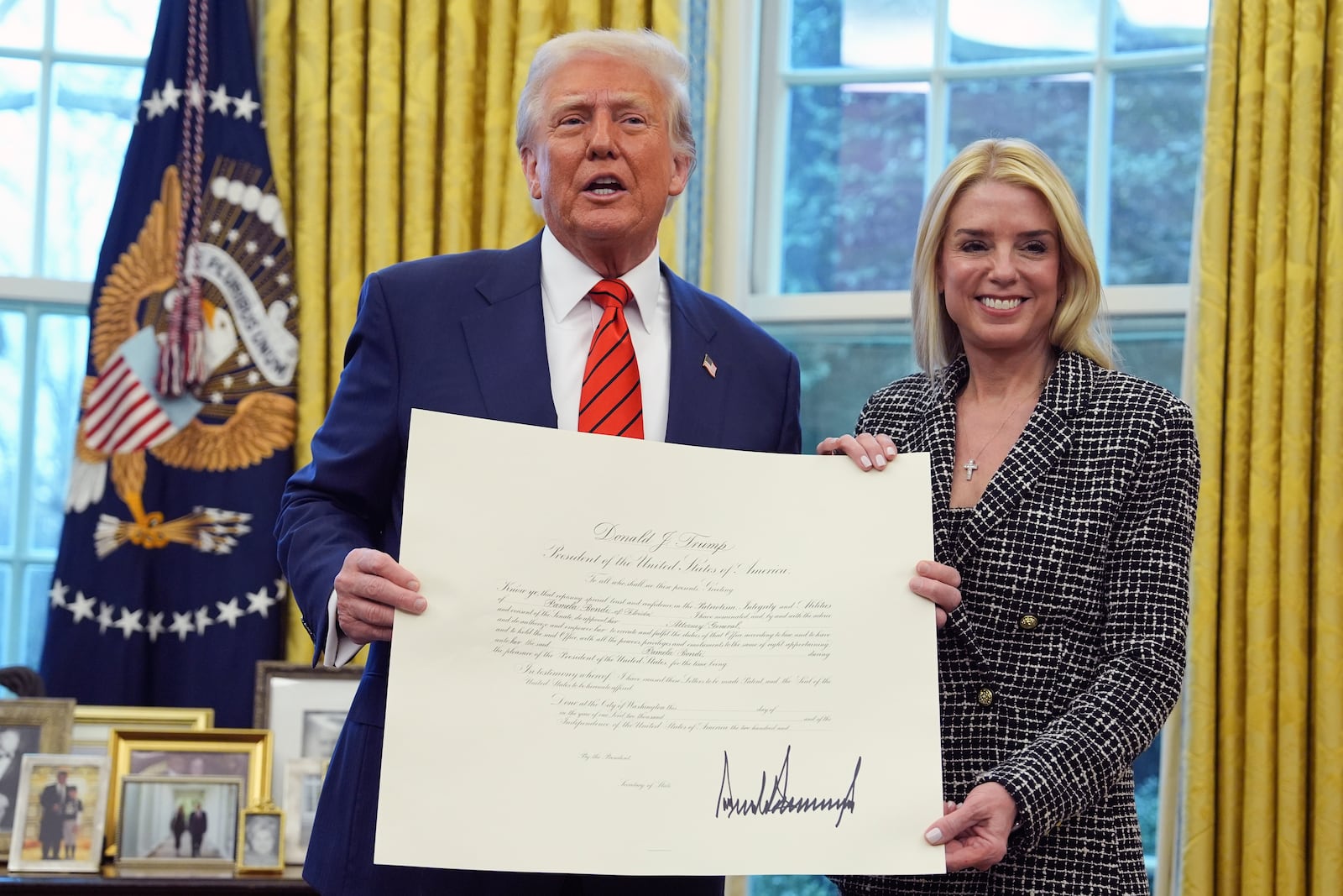 President Donald Trump presents Attorney General Pam Bondi with a document, after she was sworn in by Supreme Court Associate Justice Clarence Thomas, in the Oval Office of the White House, Wednesday, Feb. 5, 2025, in Washington. (AP Photo/Evan Vucci)