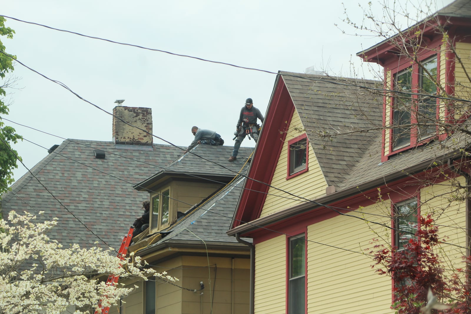 Workers on a roof of a home in East Dayton. CORNELIUS FROLIK / STAFF