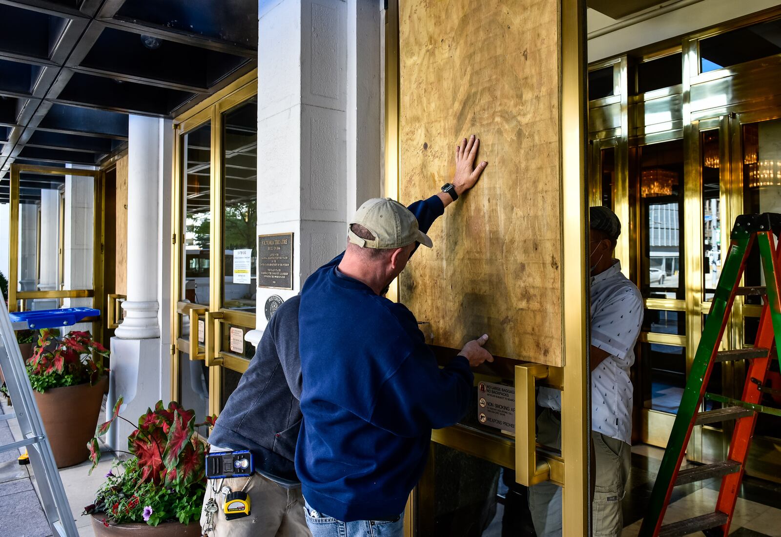 Victoria Theatre on Main Street had multiple windows and display board glass smashed in downtown Dayton Sunday morning, May 31, after protests throughout the day on Saturday in the aftermath of the death of George Floyd. CIty and county workers, business owners and volunteers spent the morning sweeping up glass and scrubbing spray paint. NICK GRAHAM / STAFF