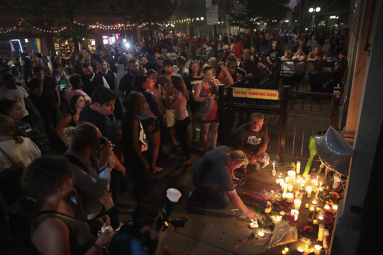 DAYTON, OHIO - AUGUST 04: Mourners leave flowers and candles at the entrance of Ned Peppers bar in the Oregon District following a memorial service to recognize the victims of a mass shooting early this morning on August 04, 2019 in Dayton, Ohio. Many of the victims were reported to have been shot in front of the bar.  At least 9 people were reported to have been killed and another 27 injured when a gunman identified as 24-year-old Connor Betts opened fire with a AR-15 style rifle.  The shooting comes less than 24 hours after a gunman in Texas opened fire at a shopping mall killing at least 20 people.  (Photo by Scott Olson/Getty Images)