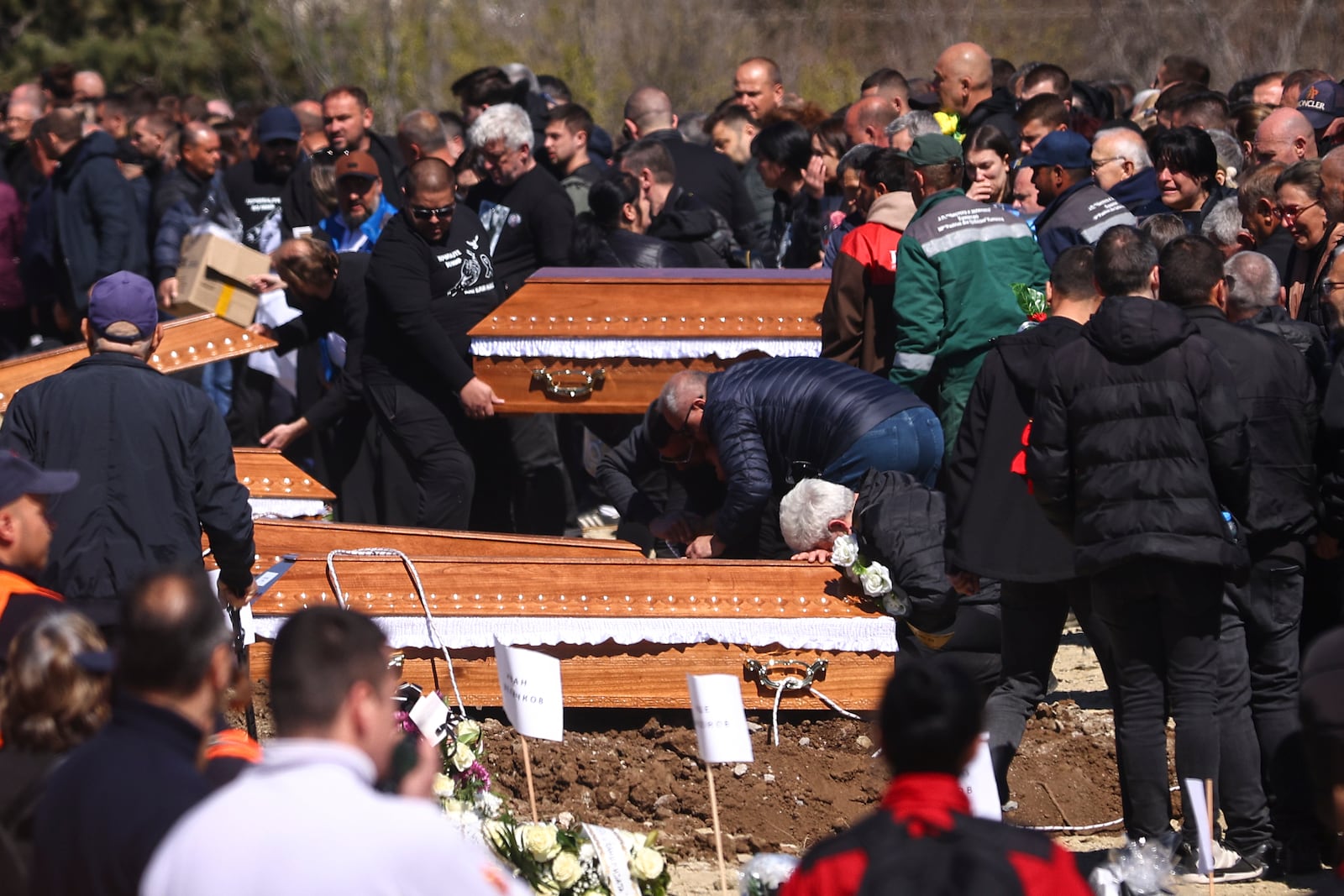 A man cries leaning on a coffin during the funeral ceremony of the victims of a massive nightclub fire in the town of Kocani, North Macedonia, Thursday, March 20, 2025. (AP Photo/Armin Durgut)