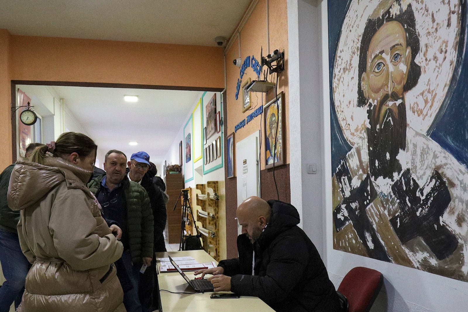 People wait in line during a parliamentary election at a polling station in the northern Serb-dominated part of ethnically divided town of Mitrovica, Kosovo, Sunday, Feb. 9, 2025. (AP Photo/Bojan Slavkovic)