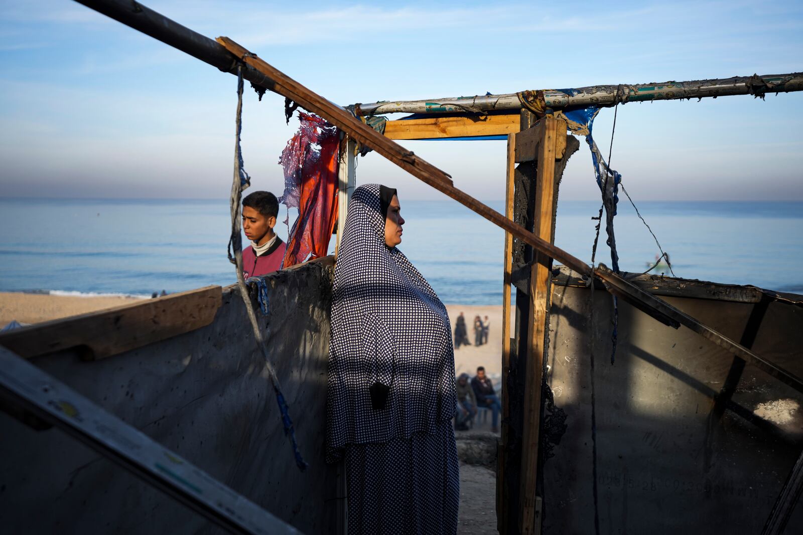 A woman stands in her damaged tent following an Israeli army strike in Deir Al-Balah in the central Gaza Strip, Tuesday, Jan. 14, 2025. (AP Photo/Abdel Kareem Hana)