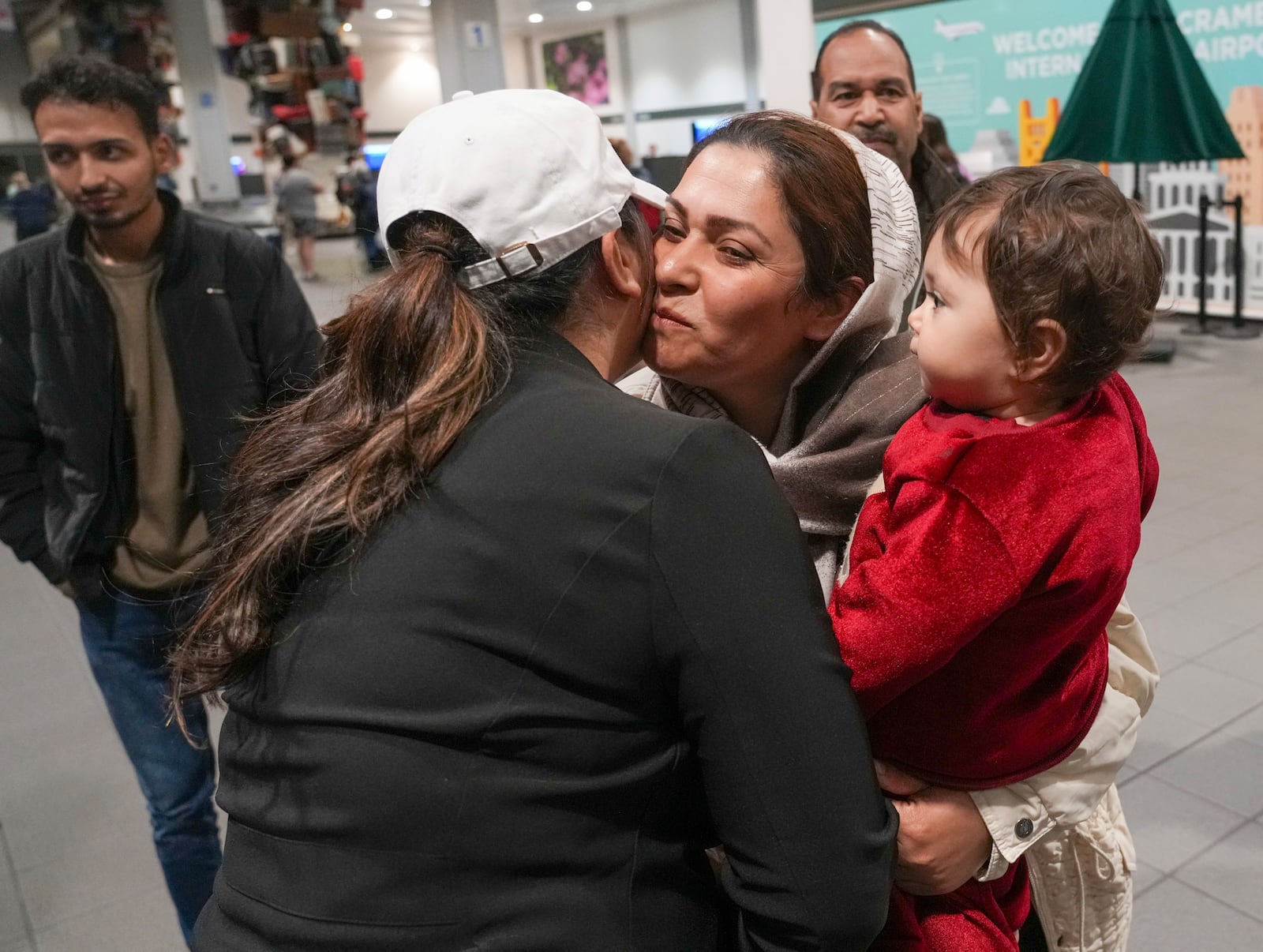 After leaving Afghanistan two-months earlier, Noria Sdeqi, center, and her daughter, Sadaf, 13 months, are welcomed by a representative of No One left Behind Organization after their arrival at the Sacramento International Airport in Sacramento, Calif., Tuesday, March 11, 2025. (AP Photo/Rich Pedroncelli)